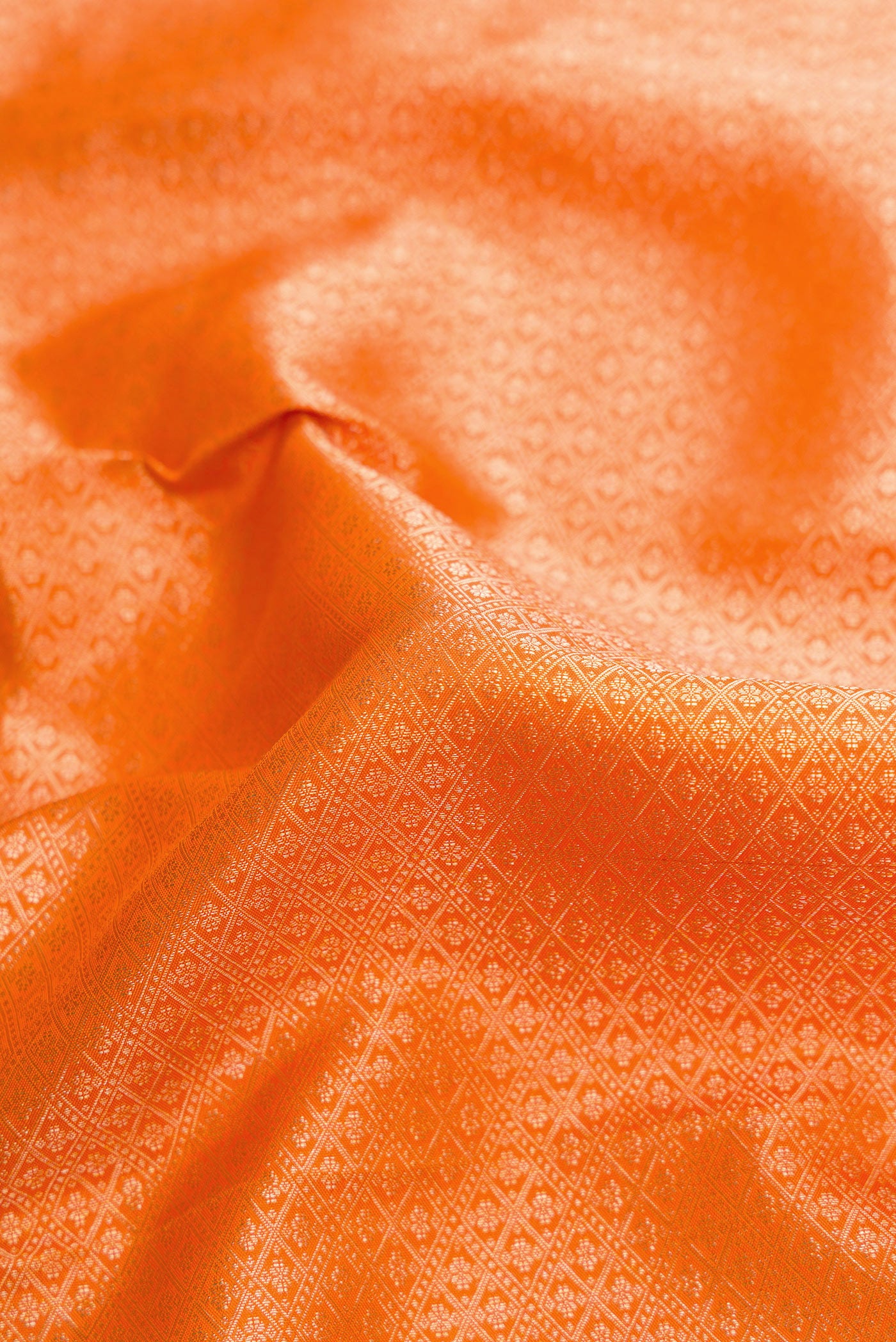 Close up of Orange Dual Tone Kanchipuram Silk Saree with Zari Brocade on the body and Zari Border.  displaying folds