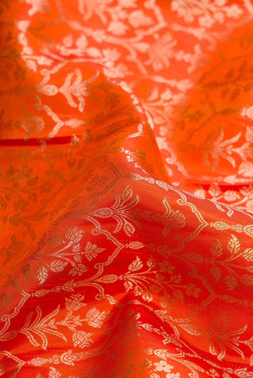 Close up of Orange Dual Tone Kanchipuram Silk Saree with Zari Brocade on the body and Zari Border.  displaying folds