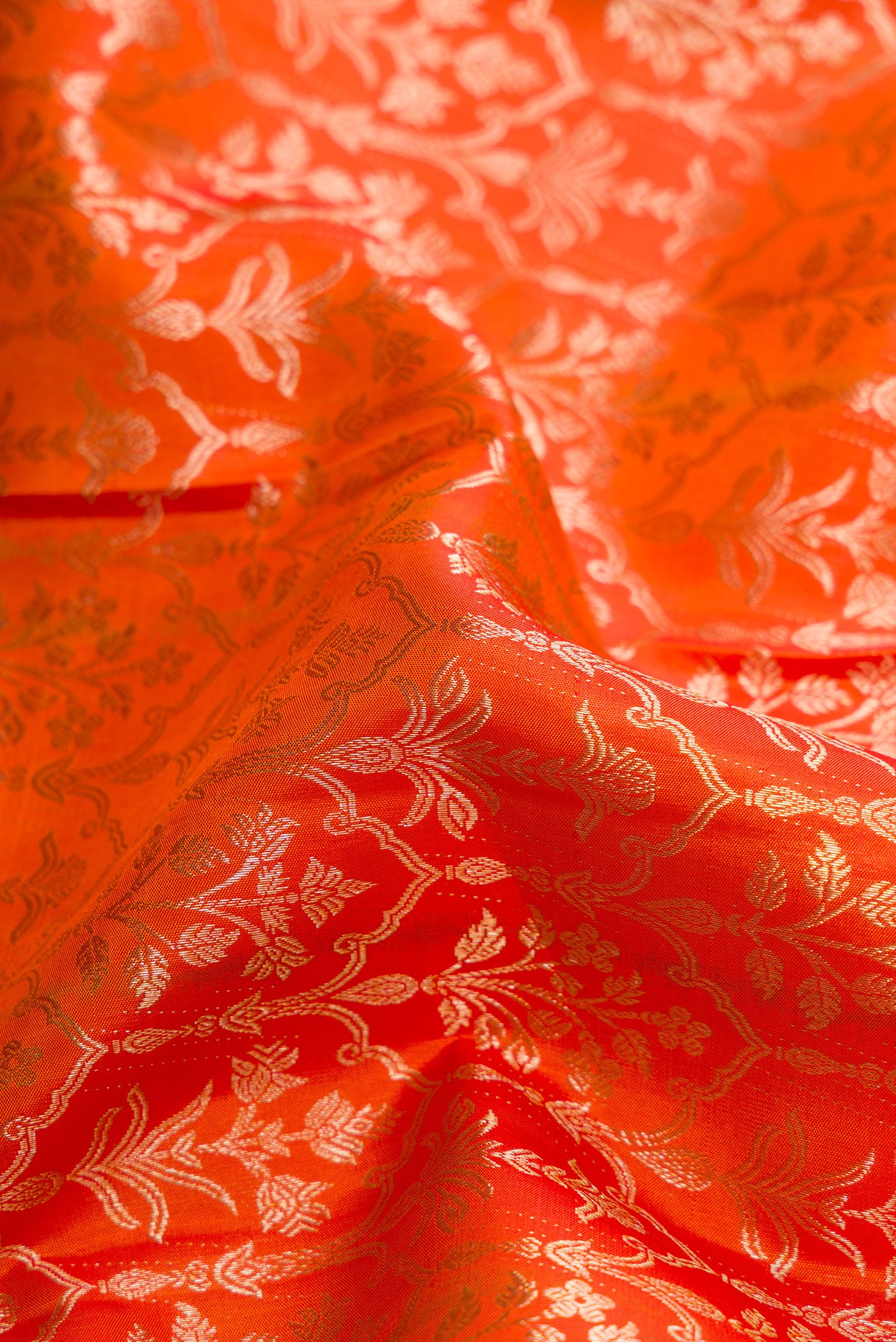 Close up of Orange Dual Tone Kanchipuram Silk Saree with Zari Brocade on the body and Zari Border.  displaying folds