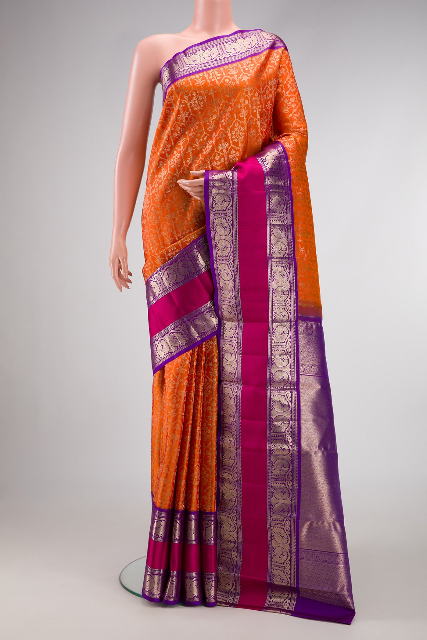 Orange Dual Tone Kanchipuram Silk Saree with Zari Brocade on the body and Zari Border.  displayed on a mannequin