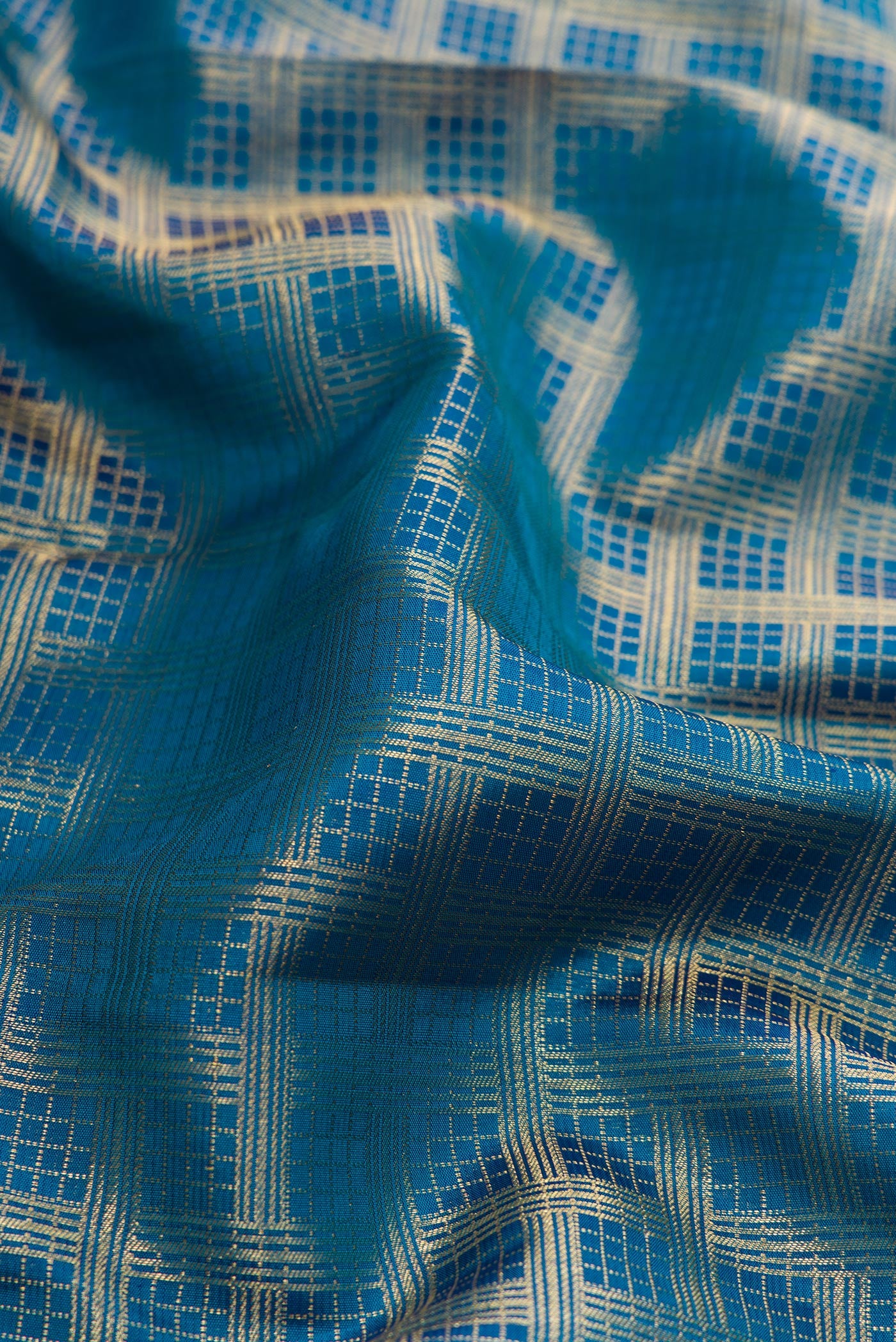 Close up of Peacock Blue Dual Tone Kanjivaram Silk Saree with Zari Brocade on the body and Zari Border.  displaying folds