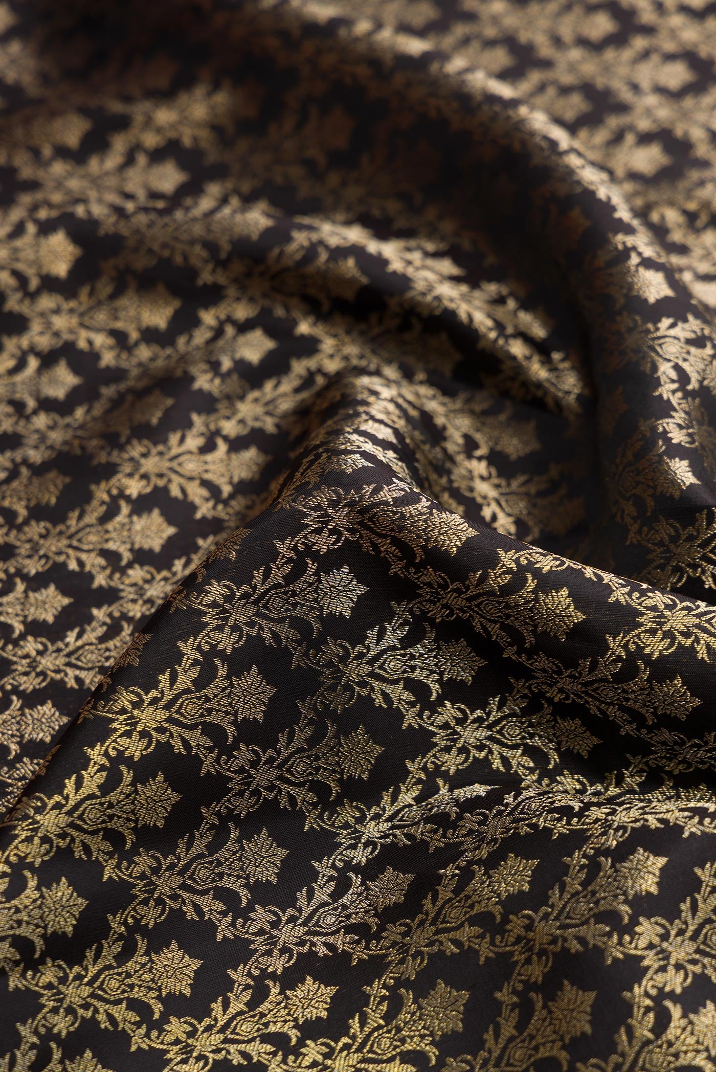 Close up of Black Dual Tone Kanjivaram Silk Saree with Zari Brocade on the body and Zari Border.  displaying folds