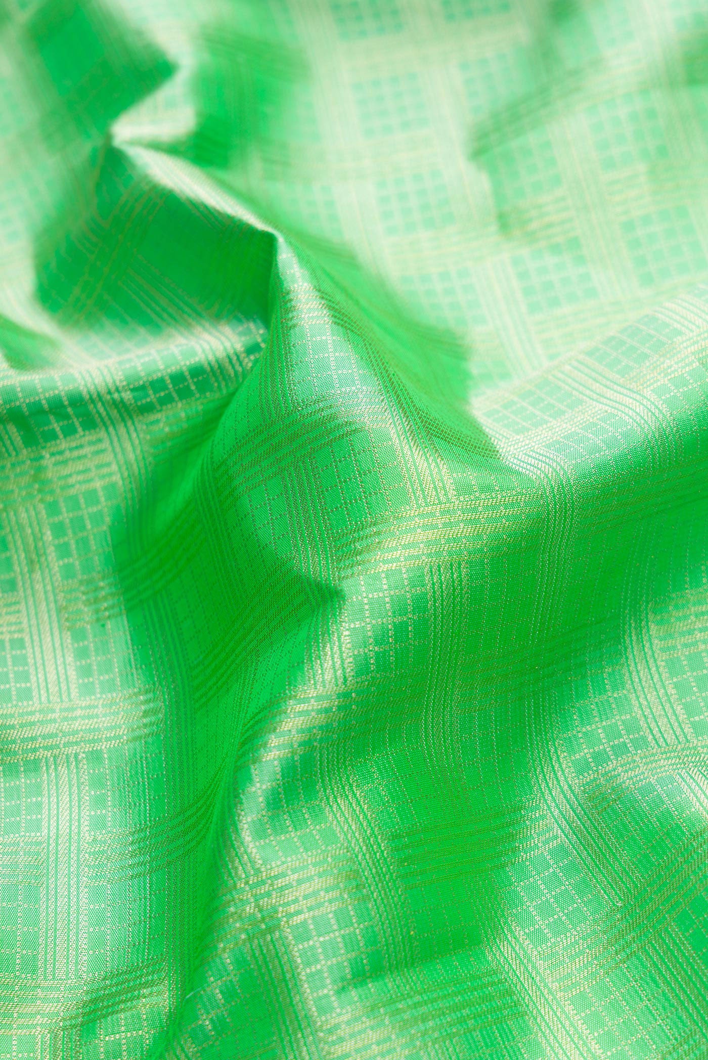 Close up of Parrot Green Dual Tone Kanjivaram Silk Saree with Zari Brocade on the body and Zari Border.  displaying folds