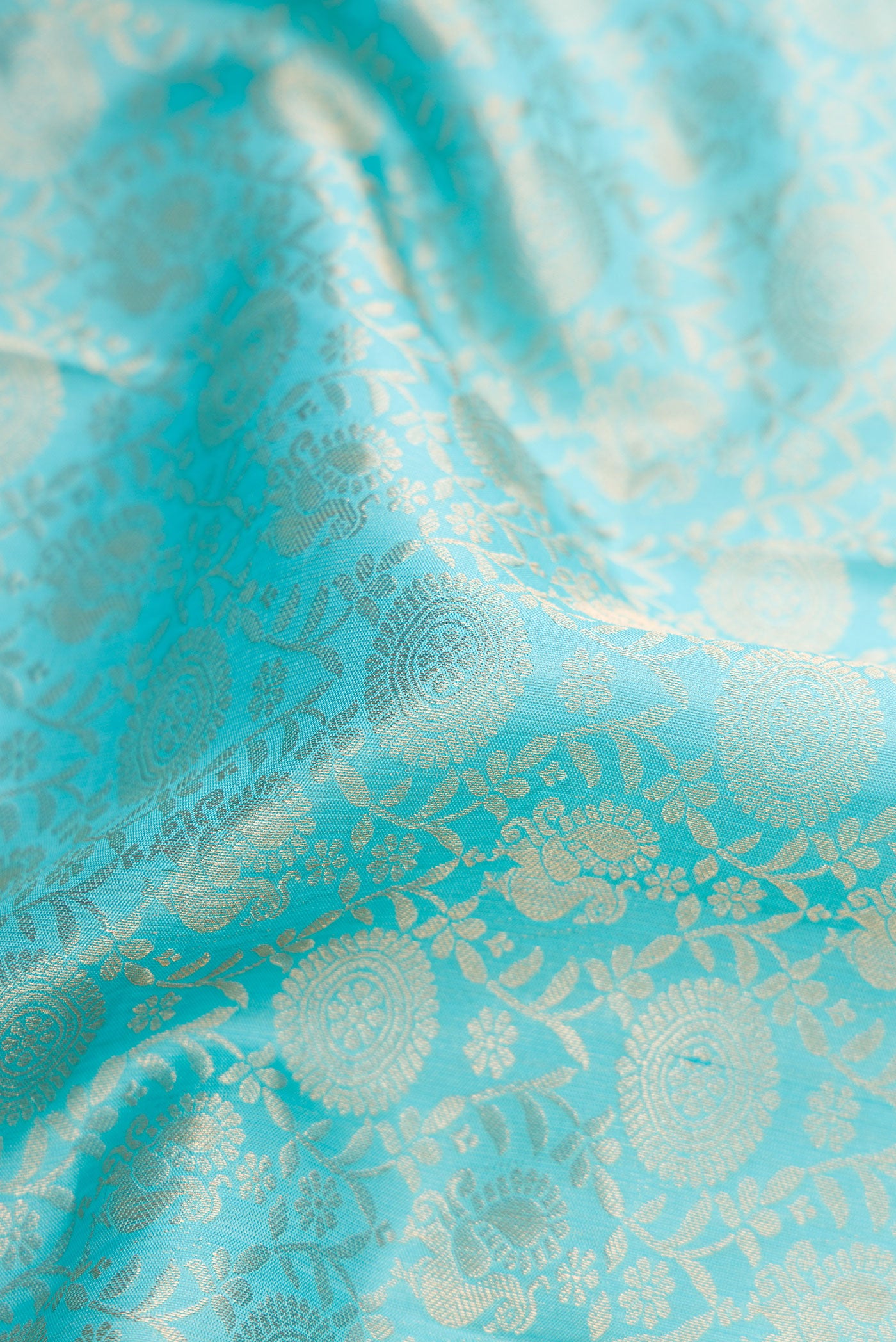 Close up of Sky Blue Dual Tone Kanjivaram Silk Saree with Zari Brocade on the body and Zari Border.  displaying folds