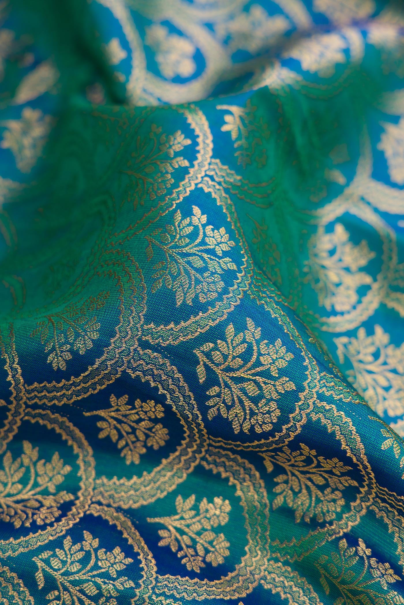 Close up of Peacock Blue Dual Tone Kanjivaram Silk Saree with Zari Brocade on the body and Zari Border.  displaying folds