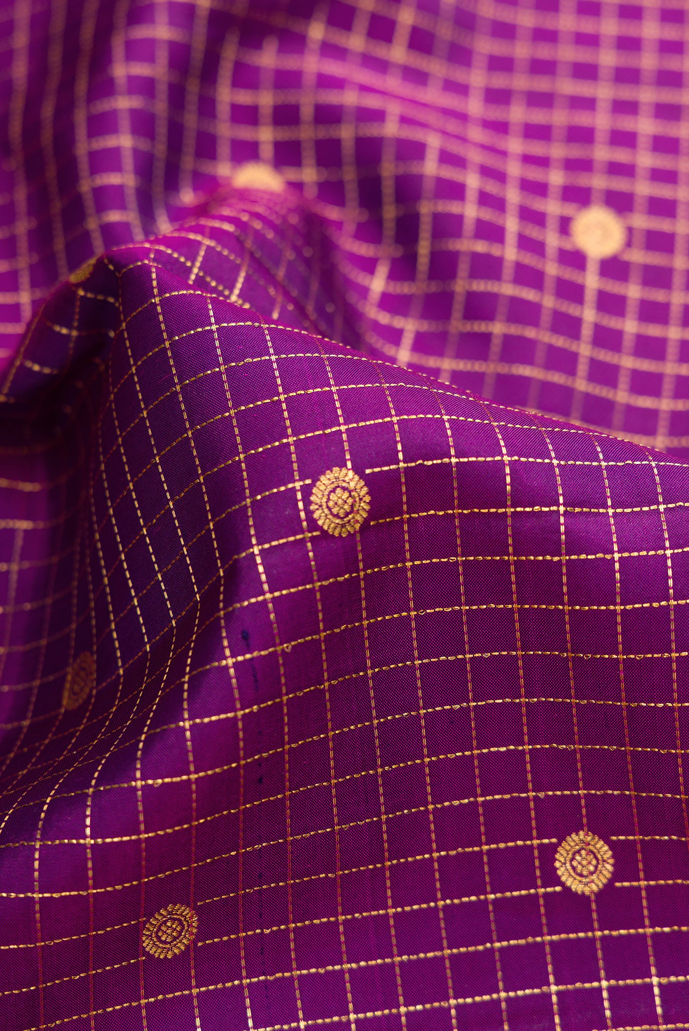 Close up of Purple Dual Tone Kanjivaram Silk Saree with Checked design on the body and Zari Border.  displaying folds