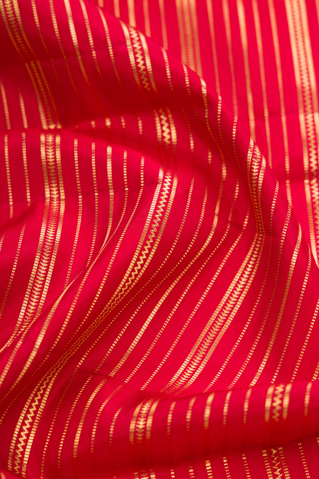 Close up of Red Dual Tone Kanjivaram Silk Saree with Stripes on the body and Zari Border.  displaying folds