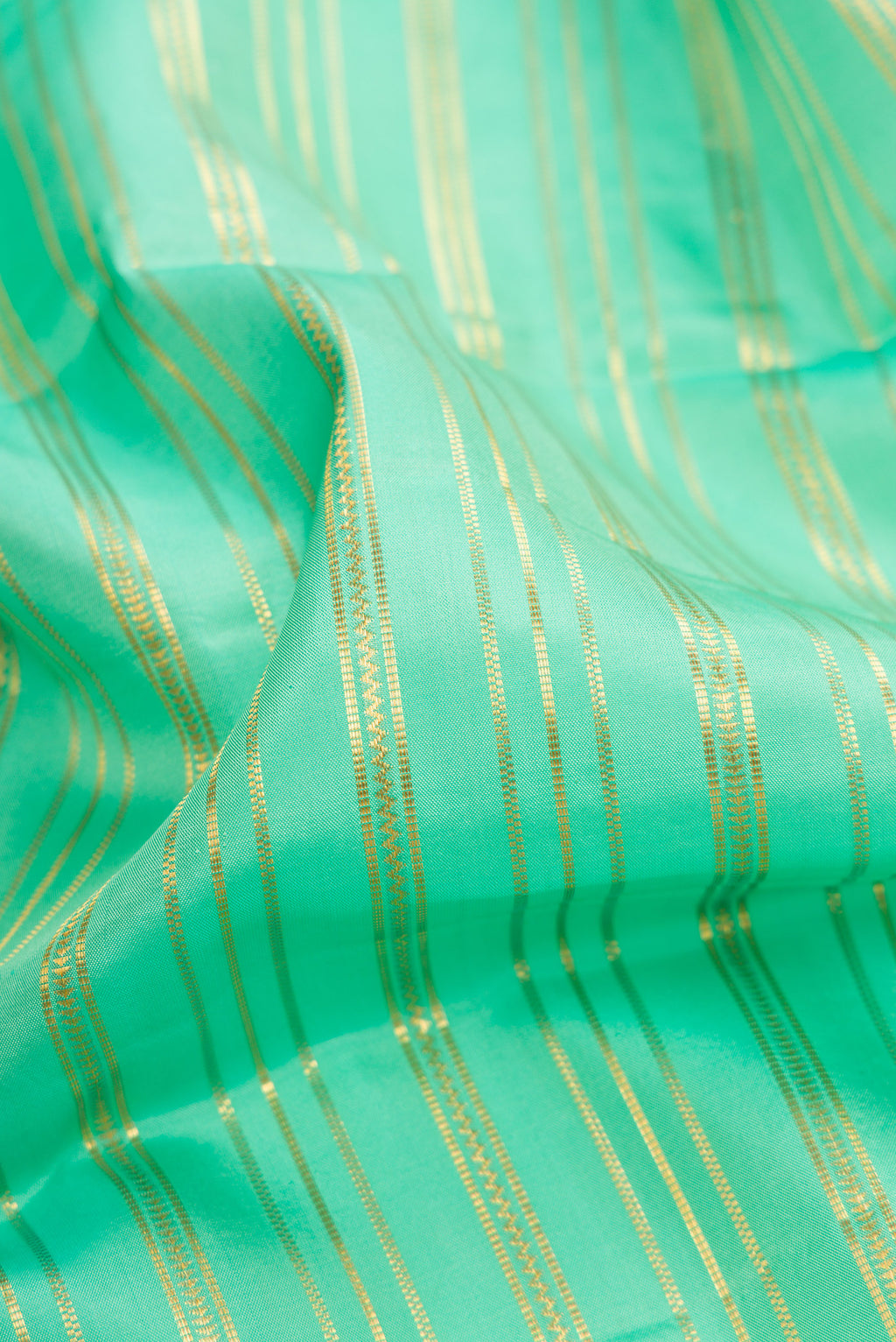 Close up of Sea Green Dual Tone Kanjivaram Silk Saree with Stripes on the body and Zari Border.  displaying folds