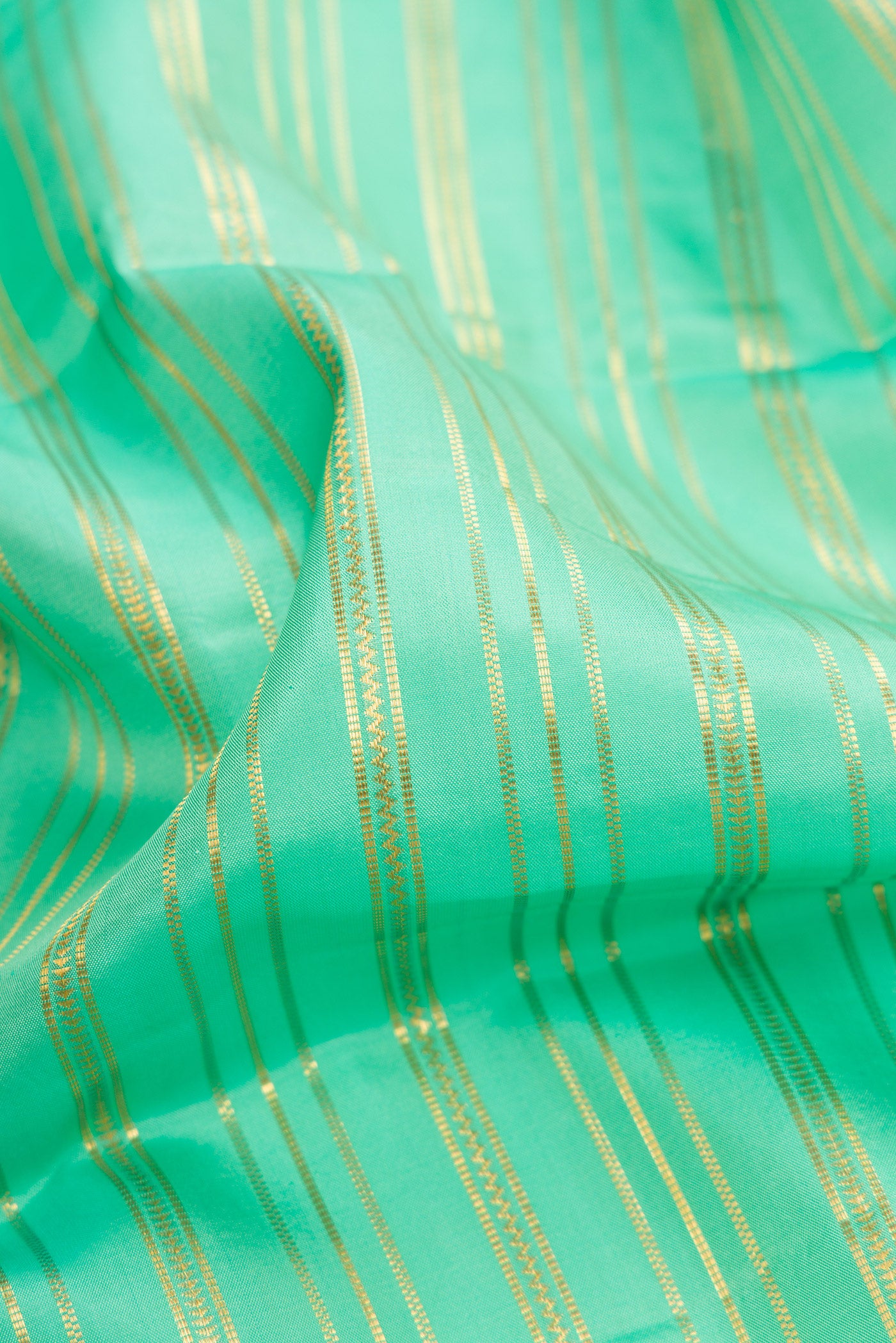 Close up of Sea Green Dual Tone Kanjivaram Silk Saree with Stripes on the body and Zari Border.  displaying folds