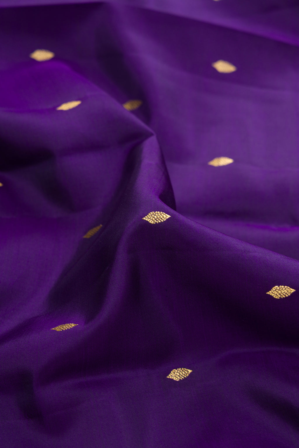 Close up of Violet Dual Tone Kanjivaram Silk Saree with Zari Butta on the body and Zari Border.  displaying folds