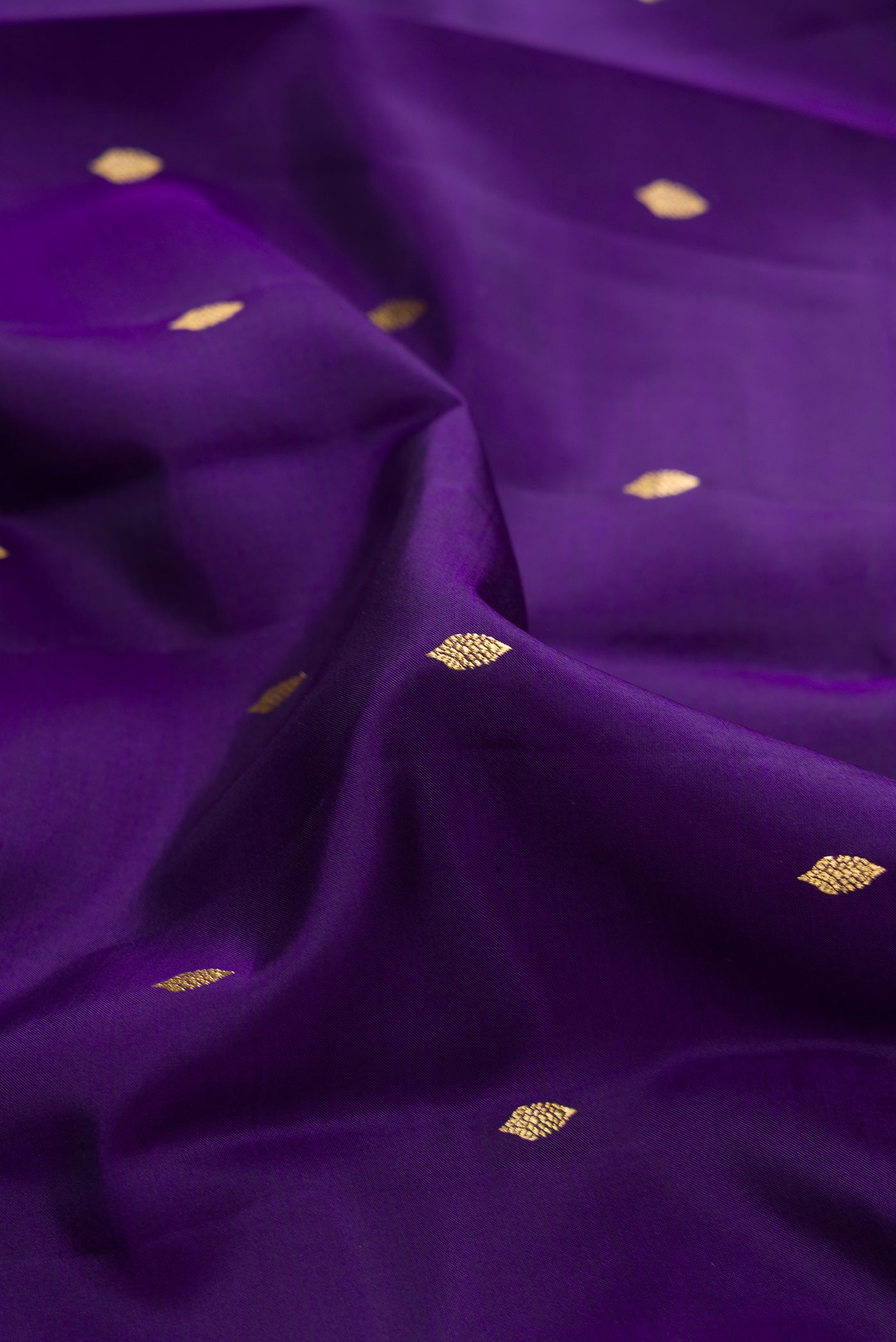Close up of Violet Dual Tone Kanjivaram Silk Saree with Zari Butta on the body and Zari Border.  displaying folds