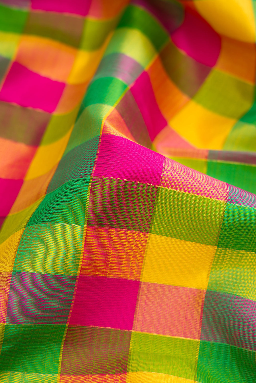Close up of Pure Silk Pure Zari Green, Pink and Yellow Color Kanjivaram Saree with Checked design on the body and Zari Border.  displaying folds