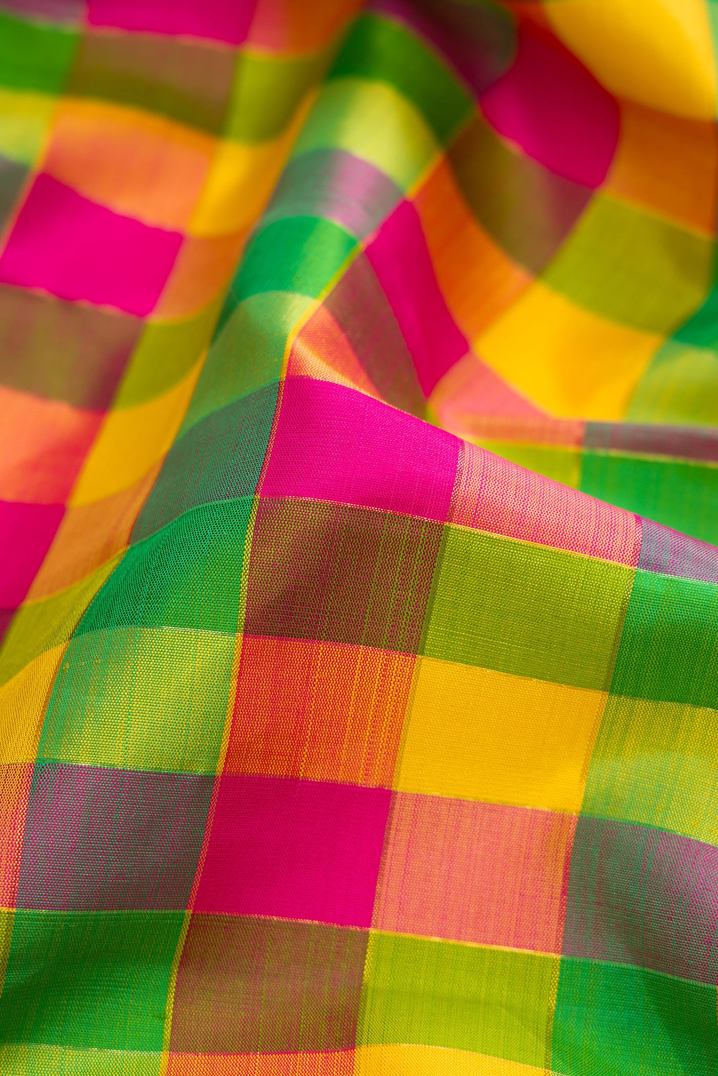 Close up of Pure Silk Pure Zari Green, Pink and Yellow Color Kanjivaram Saree with Checked design on the body and Zari Border.  displaying folds