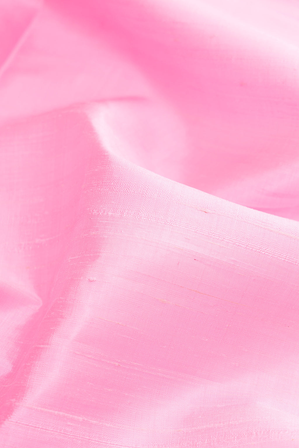Close up of Pink Raw Silk Saree with Plain Body and Zari Border.  displaying folds