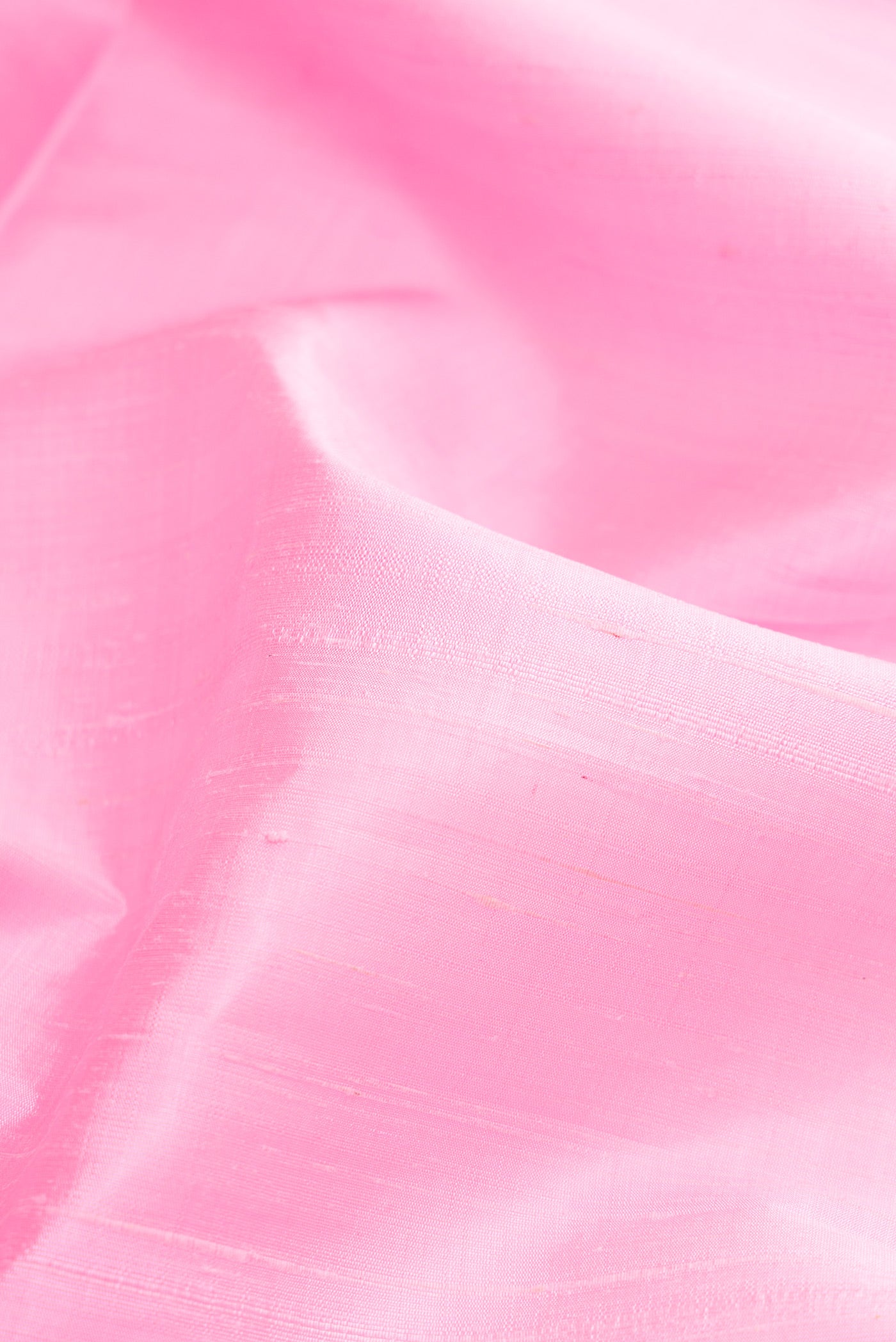 Close up of Pink Raw Silk Saree with Plain Body and Zari Border.  displaying folds