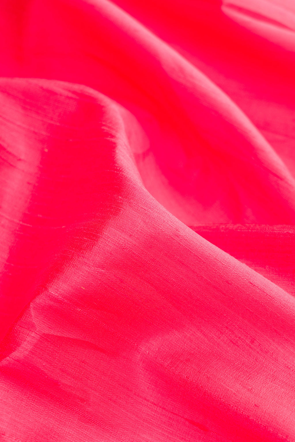Close up of Pink Raw Silk Saree with Plain Body and Zari Border.  displaying folds