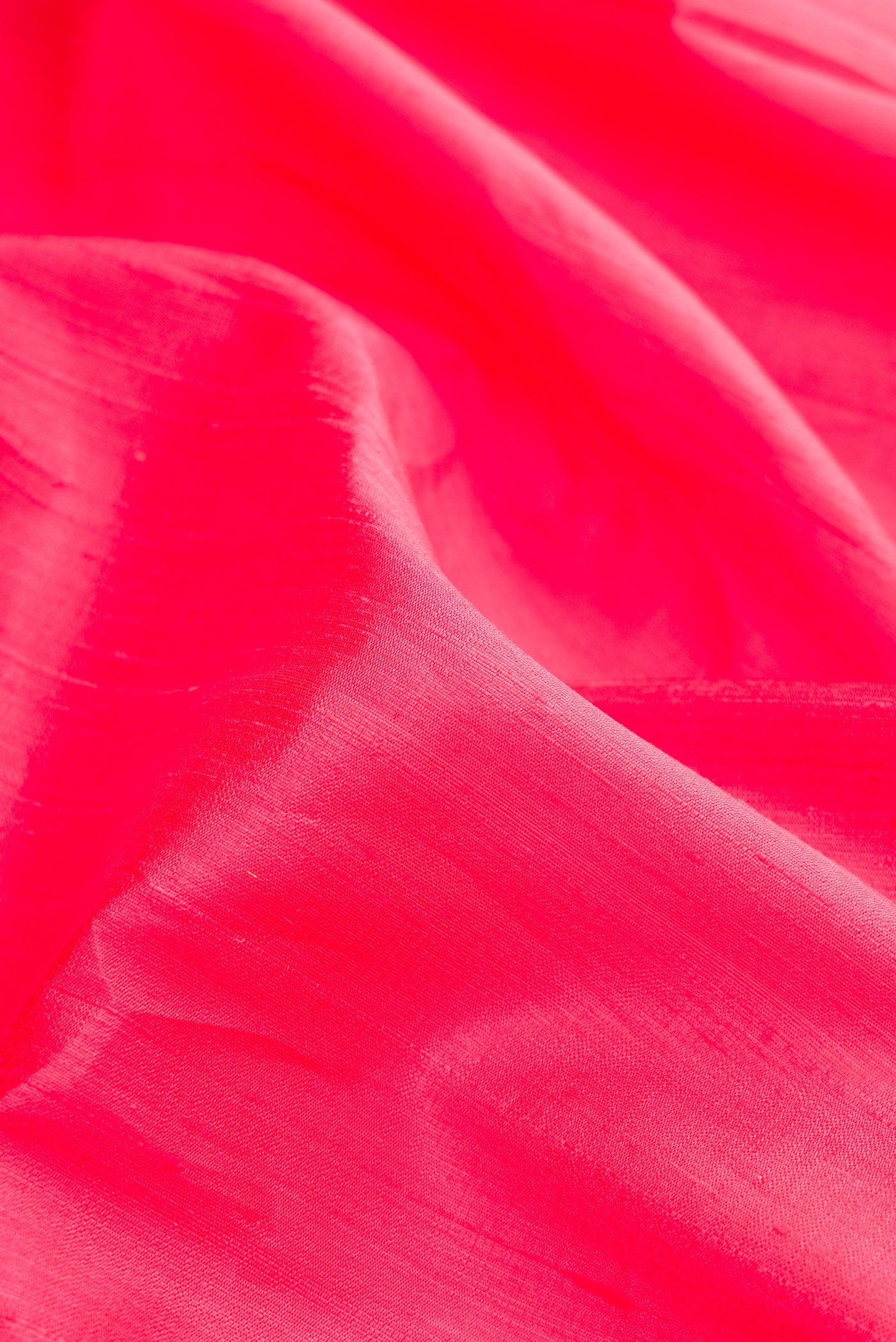 Close up of Pink Raw Silk Saree with Plain Body and Zari Border.  displaying folds