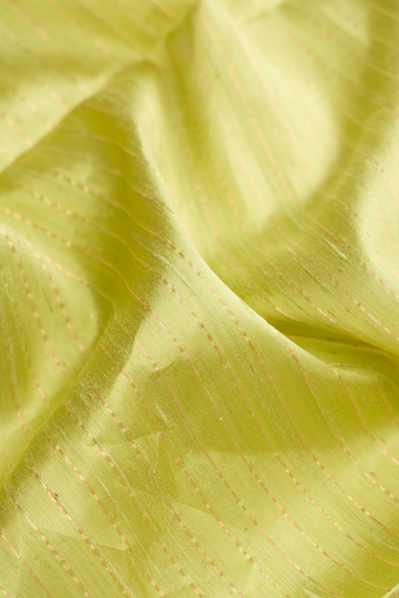 Close up of Pista Green Dual Tone Raw Silk Saree with Checked design on the body and Temple Border.  displaying folds
