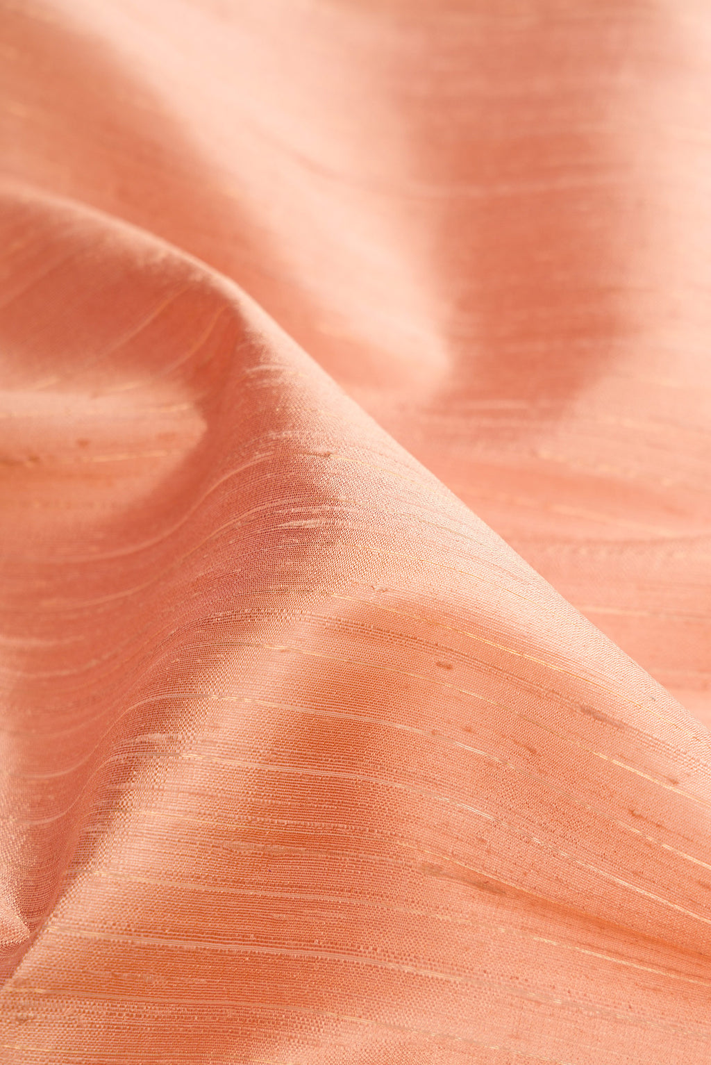 Close up of Rose Gold Dual Tone Raw Silk Saree with Stripes on the body and Zari Border.  displaying folds