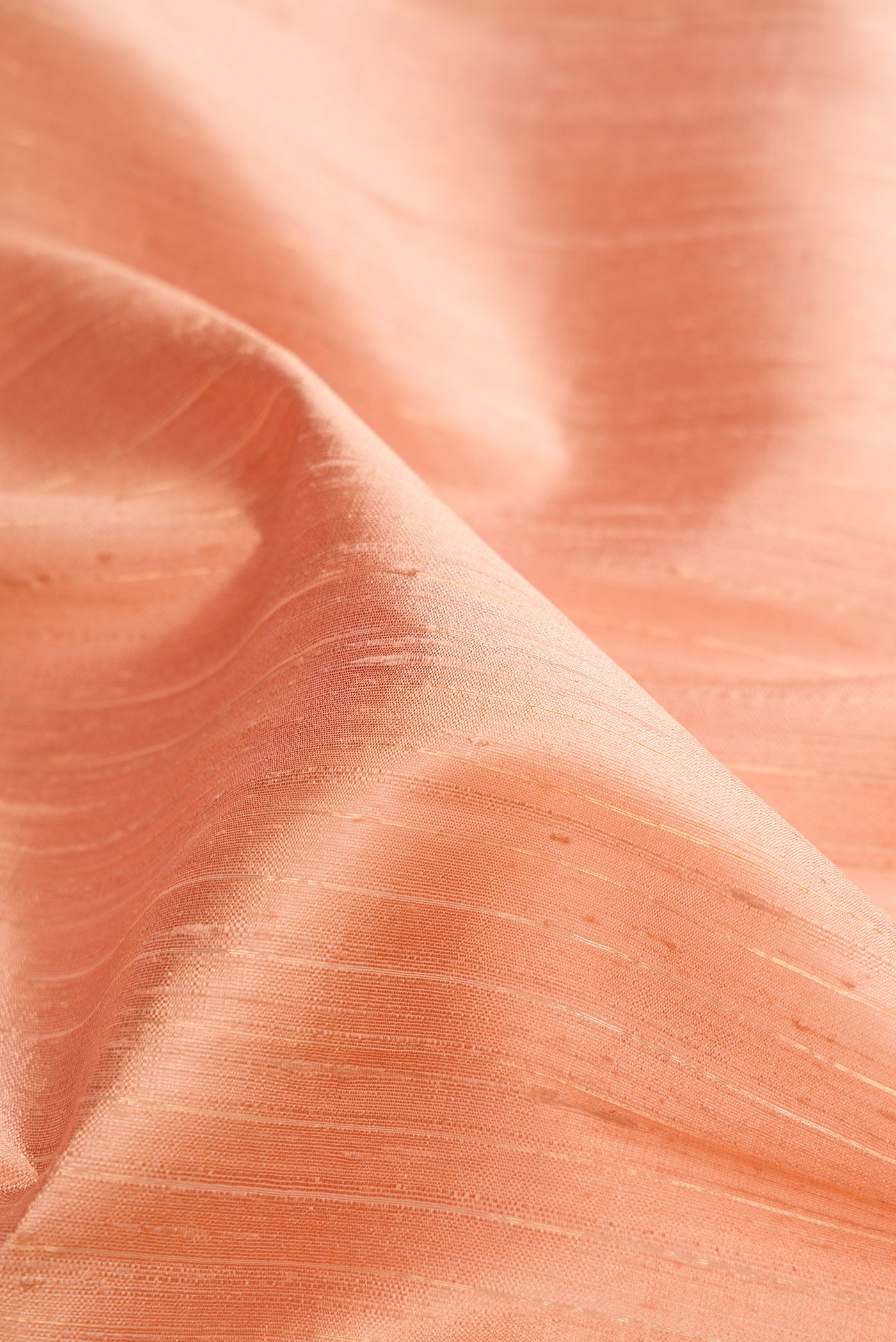 Close up of Rose Gold Dual Tone Raw Silk Saree with Stripes on the body and Zari Border.  displaying folds