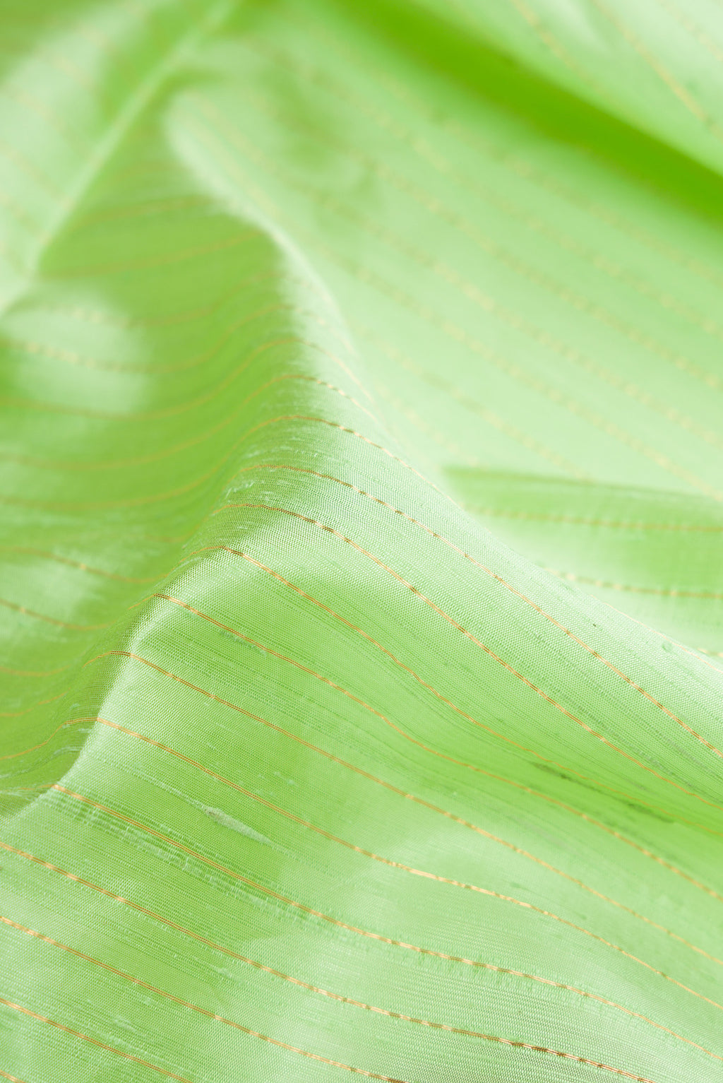 Close up of Light Green Raw Silk Saree with Stripes on the body and Zari Border.  displaying folds