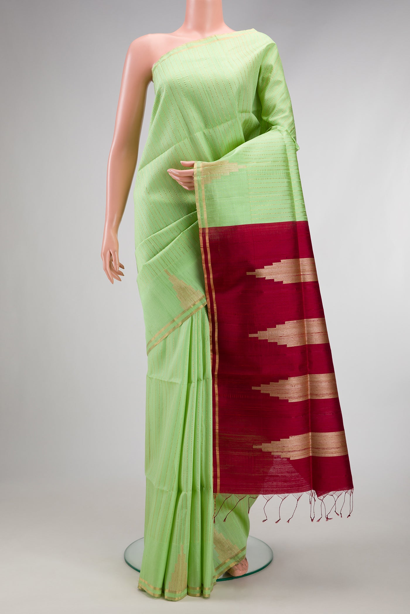 Light Green Raw Silk Saree with Stripes on the body and Zari Border.  displayed on a mannequin