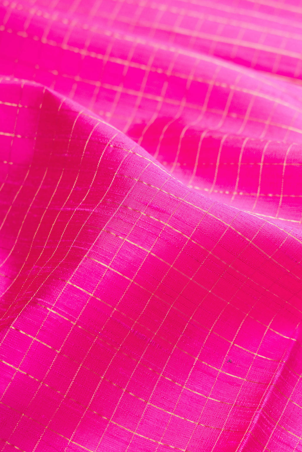 Close up of Pink Raw Silk Saree with Checked design on the body and Zari Border.  displaying folds