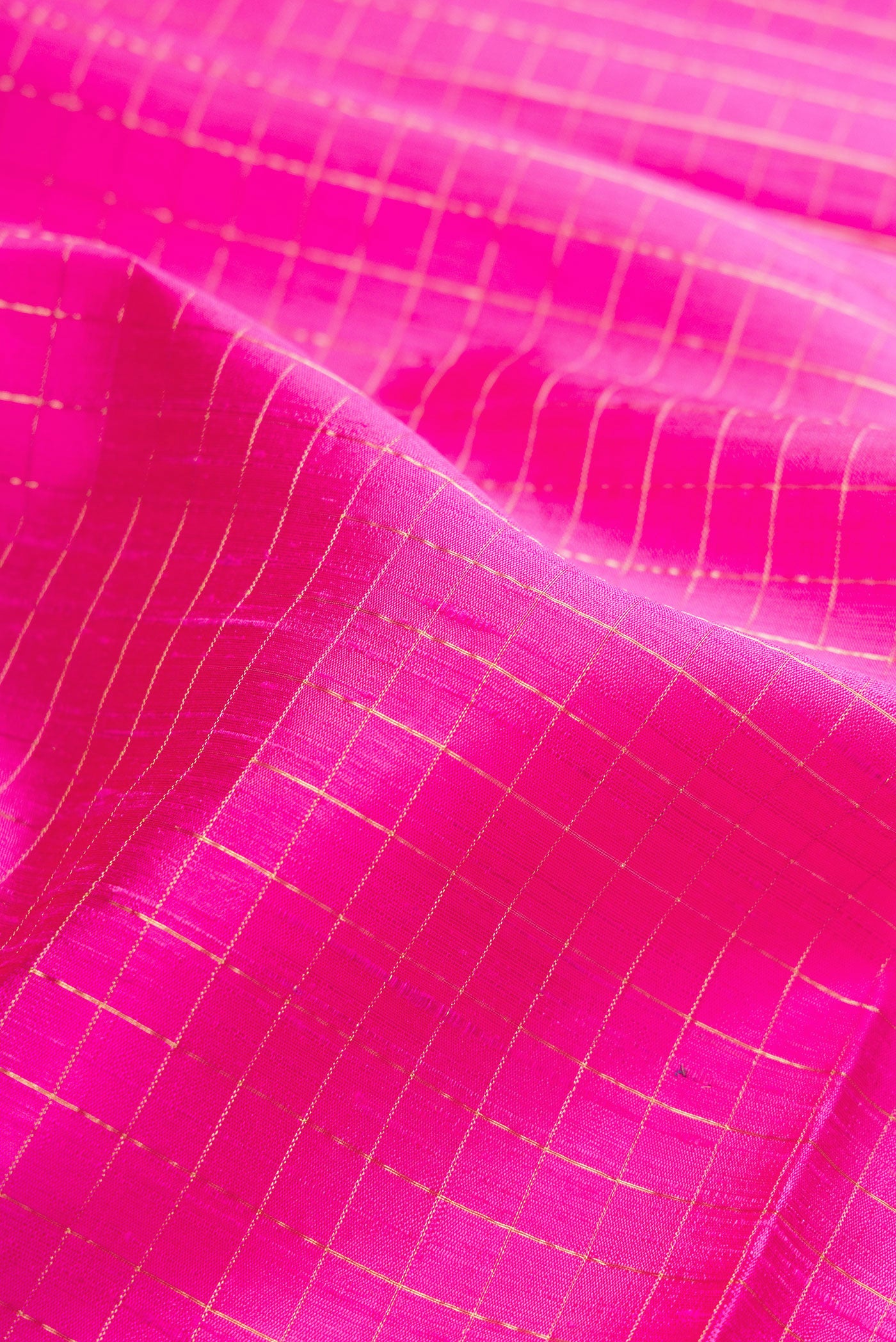 Close up of Pink Raw Silk Saree with Checked design on the body and Zari Border.  displaying folds
