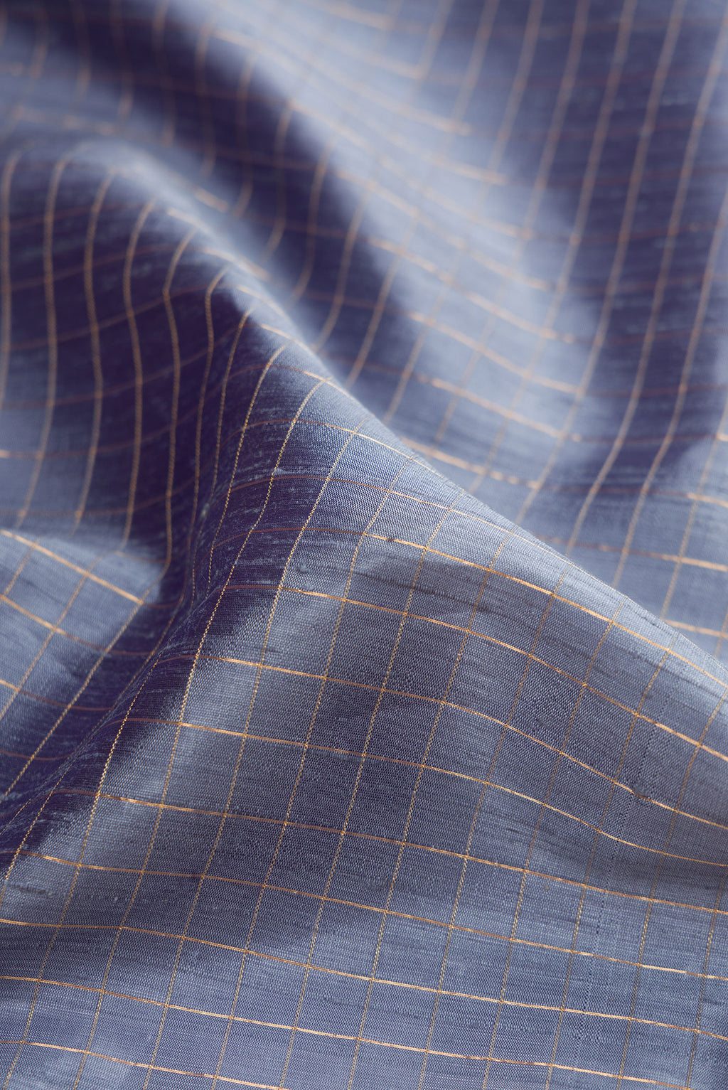 Close up of Grey Raw Silk Saree with Checked design on the body and Zari Border.  displaying folds
