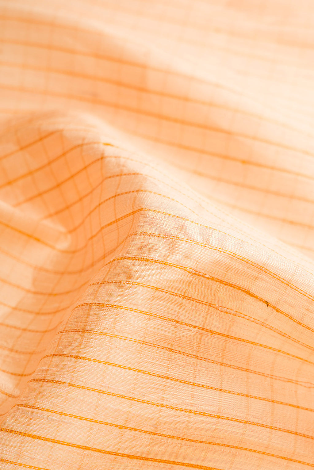 Close up of Sandal Raw Silk Saree with Checked design on the body and Thin Zari Line.  displaying folds