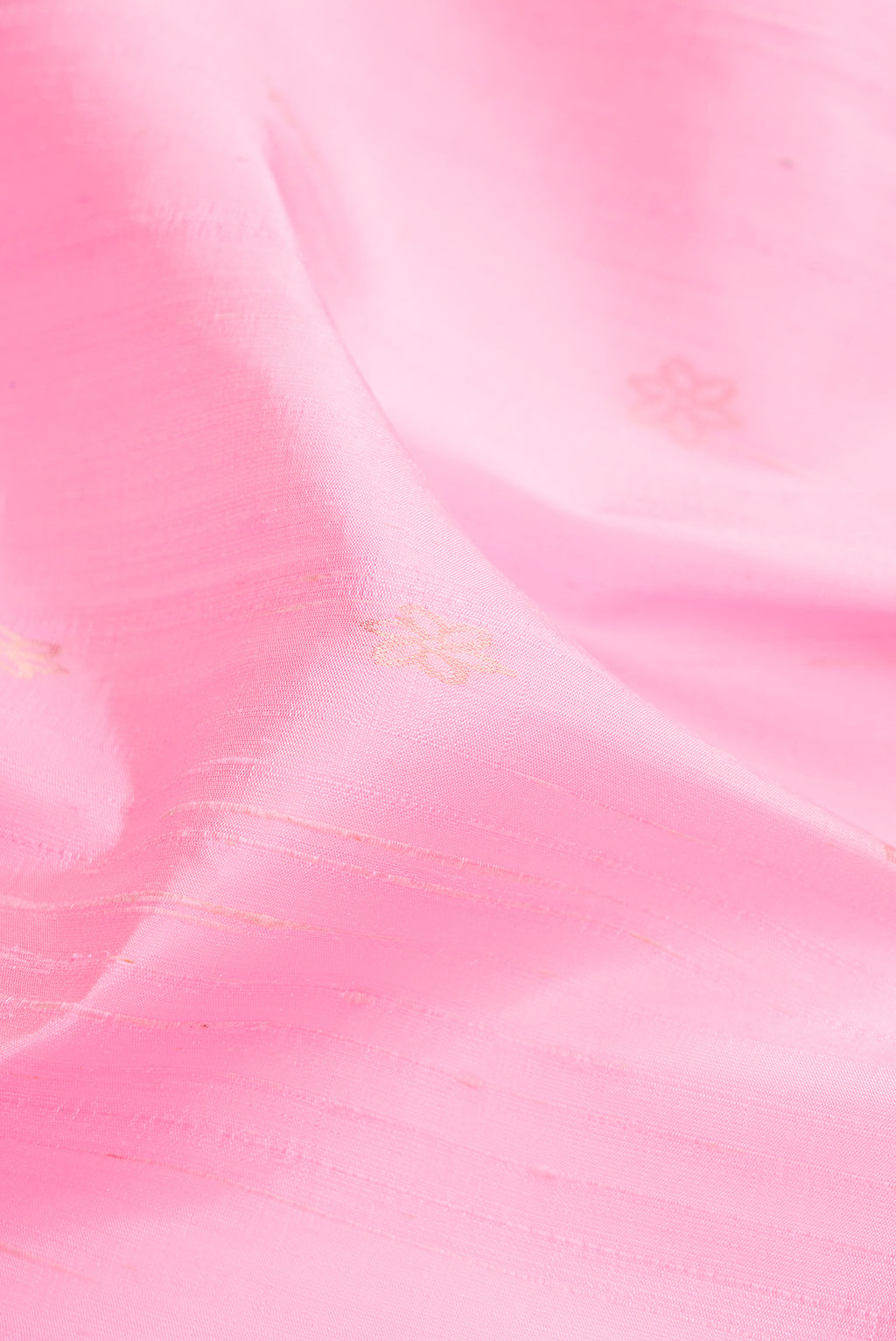 Close up of Rose pink Raw Silk Saree with Zari Butta on the body and Thin Zari Line.  displaying folds