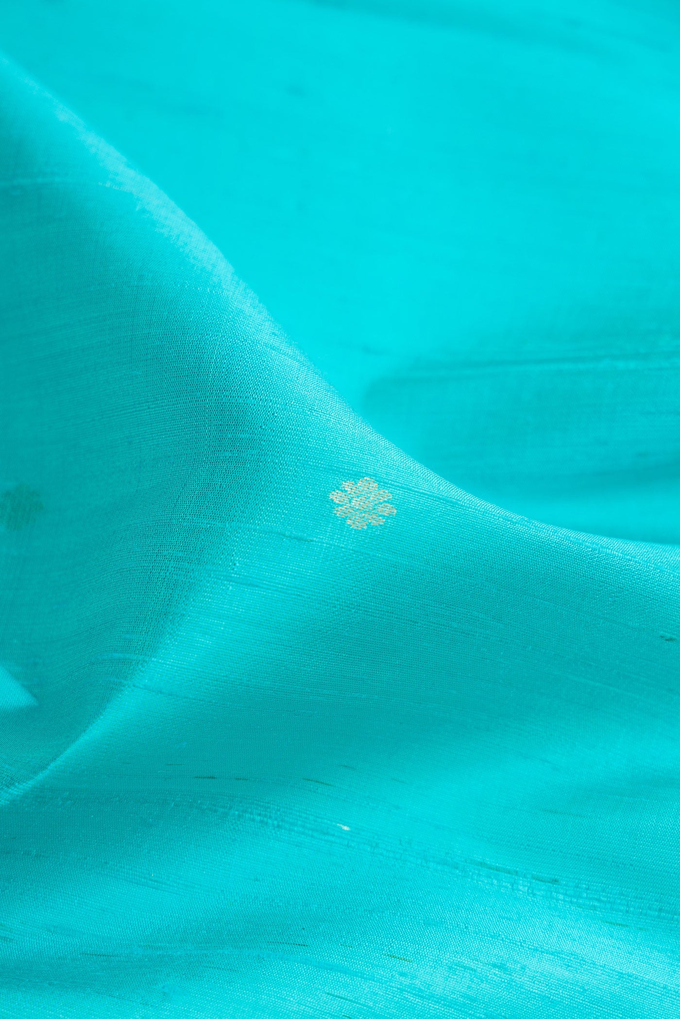 Close up of Sky Blue Dual Tone Raw Silk Saree with Zari Butta on the body and Zari Border.  displaying folds