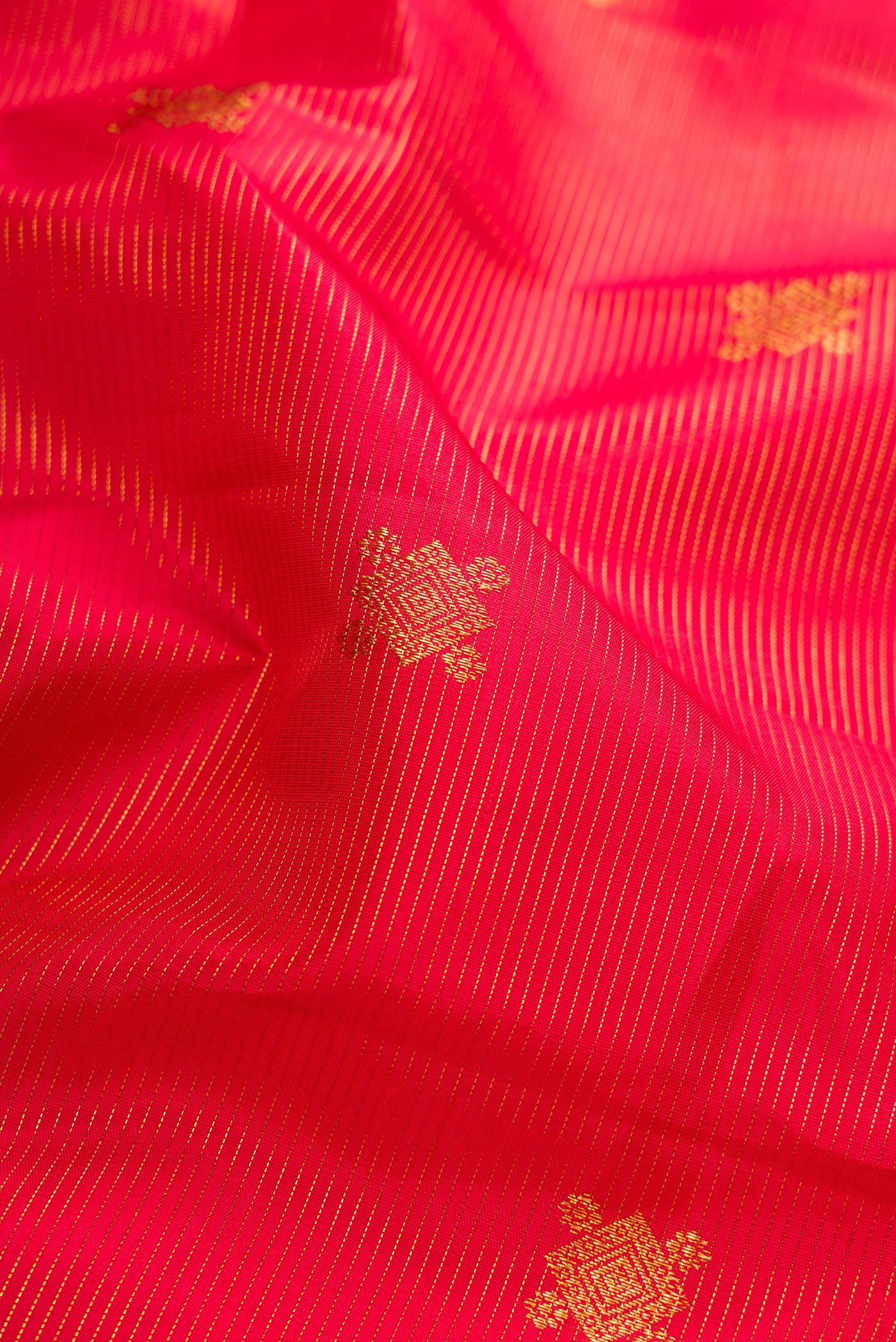 Close up of Pure Silk Pure Zari Red Dual Tone Kanjivaram Saree with Stripes on the body and Zari Border.  displaying folds