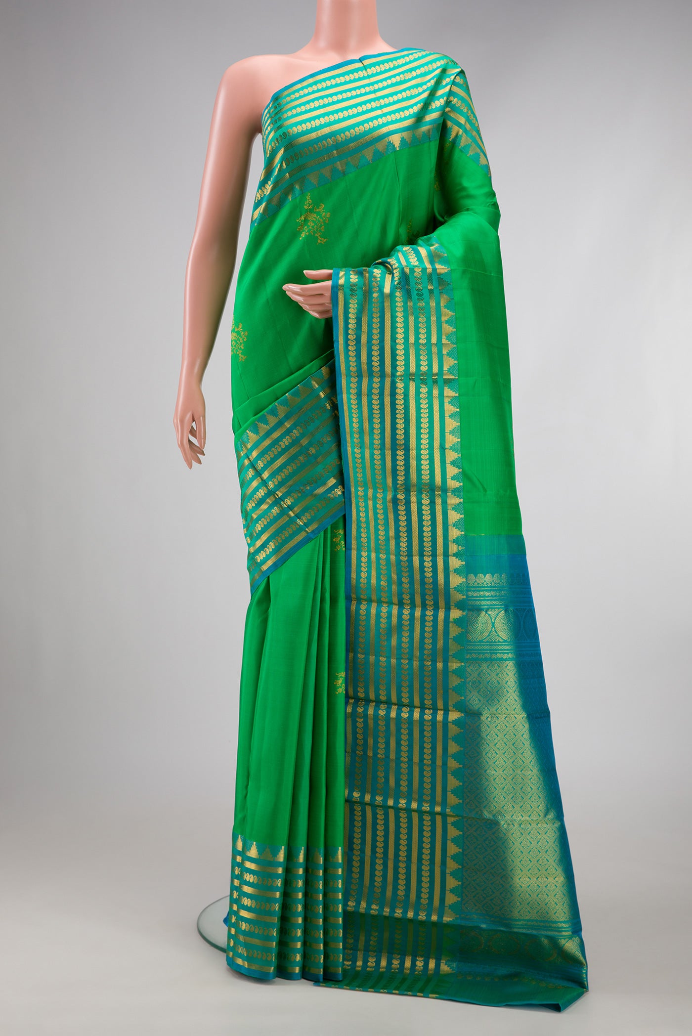 Green Kanchipuram Silk Saree with Zari Butta on the body and Fancy Border.  displayed on a mannequin