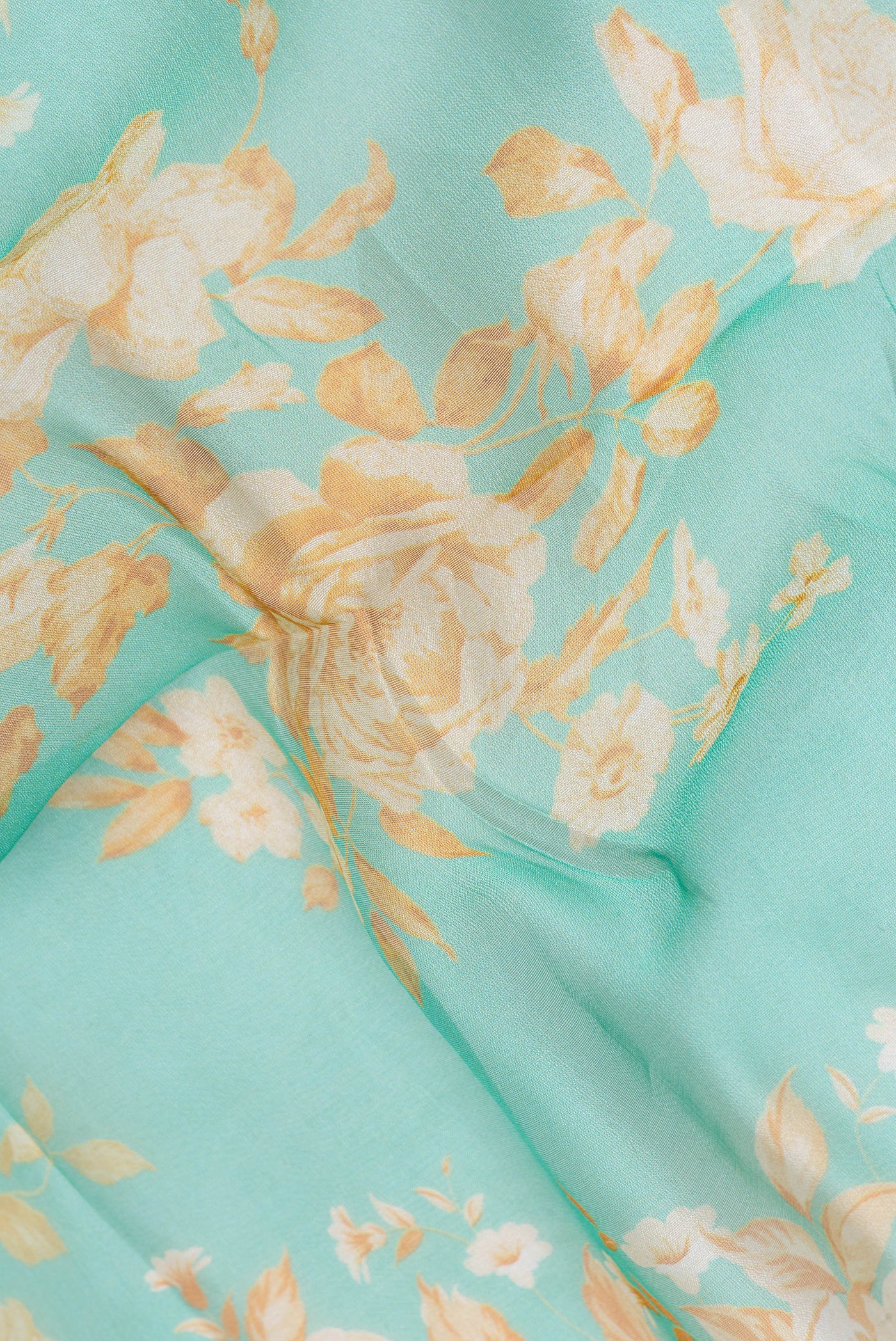 Close up of Sea Green Organza Silk Saree with Floral Print on the body and Zari Border.  displaying folds