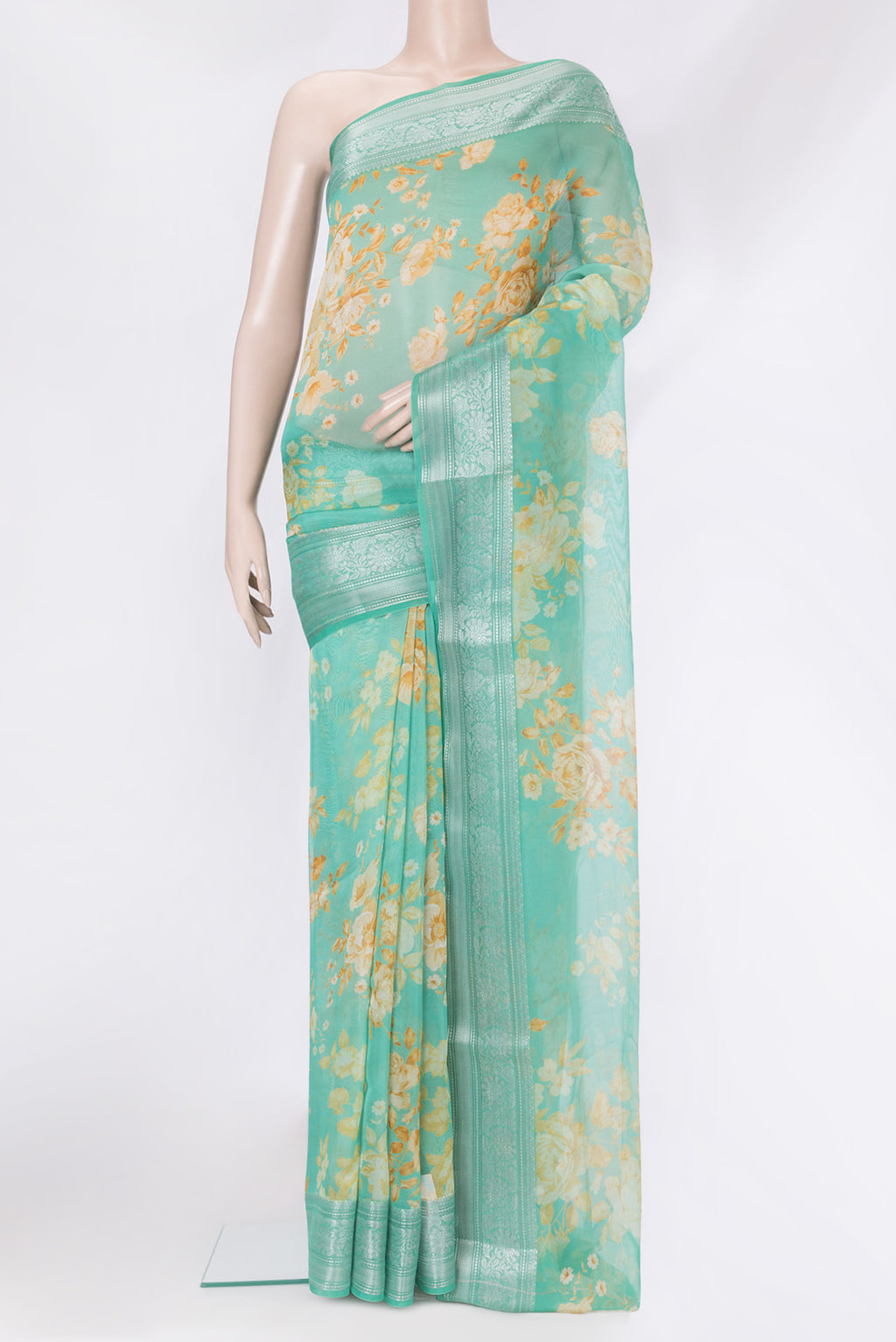 Sea Green Organza Silk Saree with Floral Print on the body and Zari Border.  displayed on a mannequin
