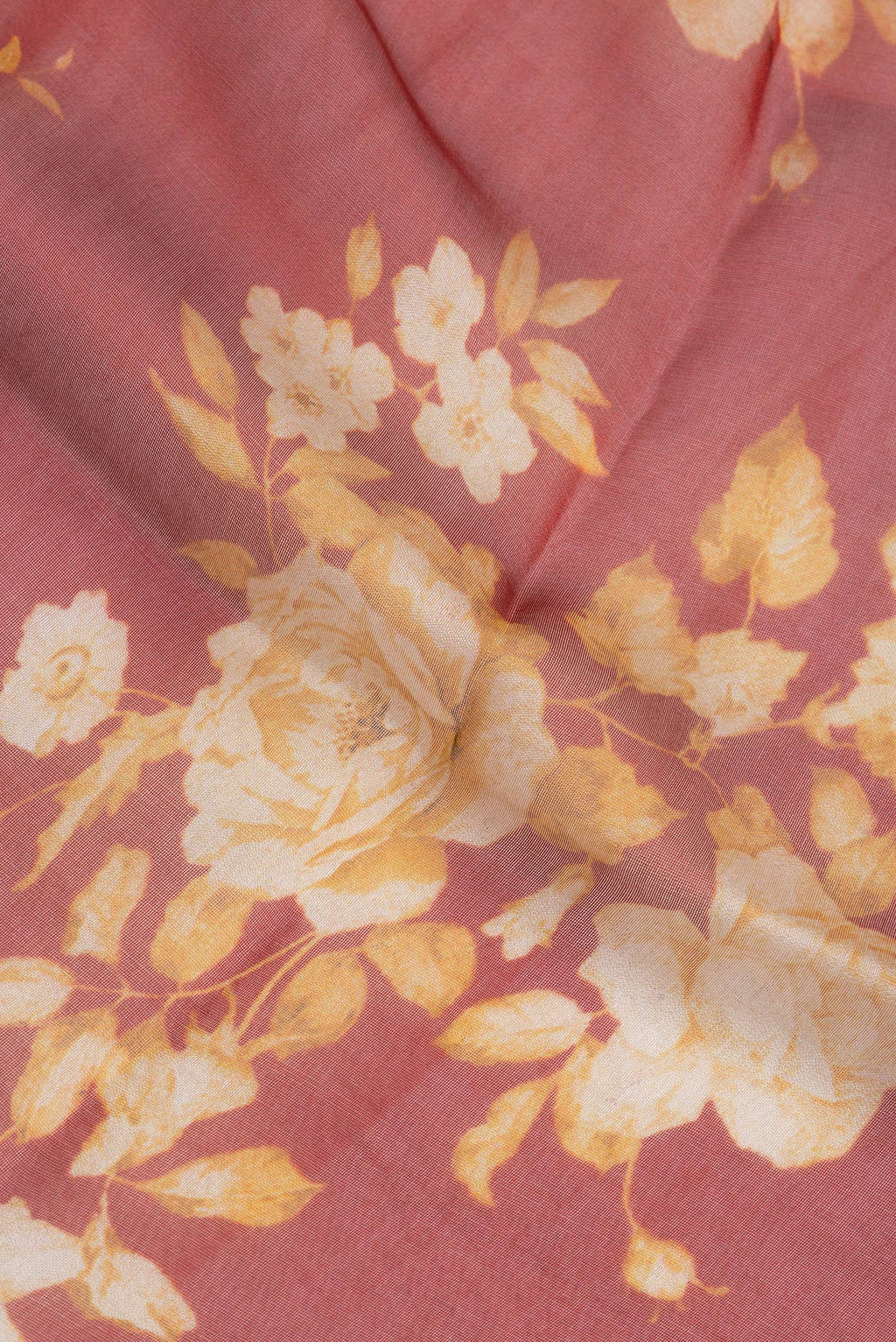 Close up of Rust Organza Silk Saree with Printed design on the body and Zari Border.  displaying folds
