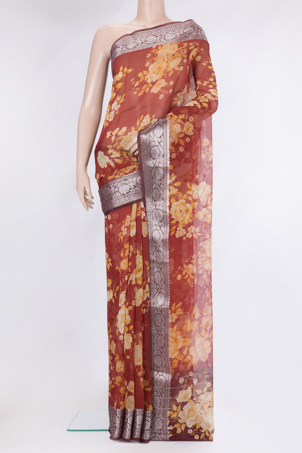Rust Organza Silk Saree with Printed design on the body and Zari Border.  displayed on a mannequin