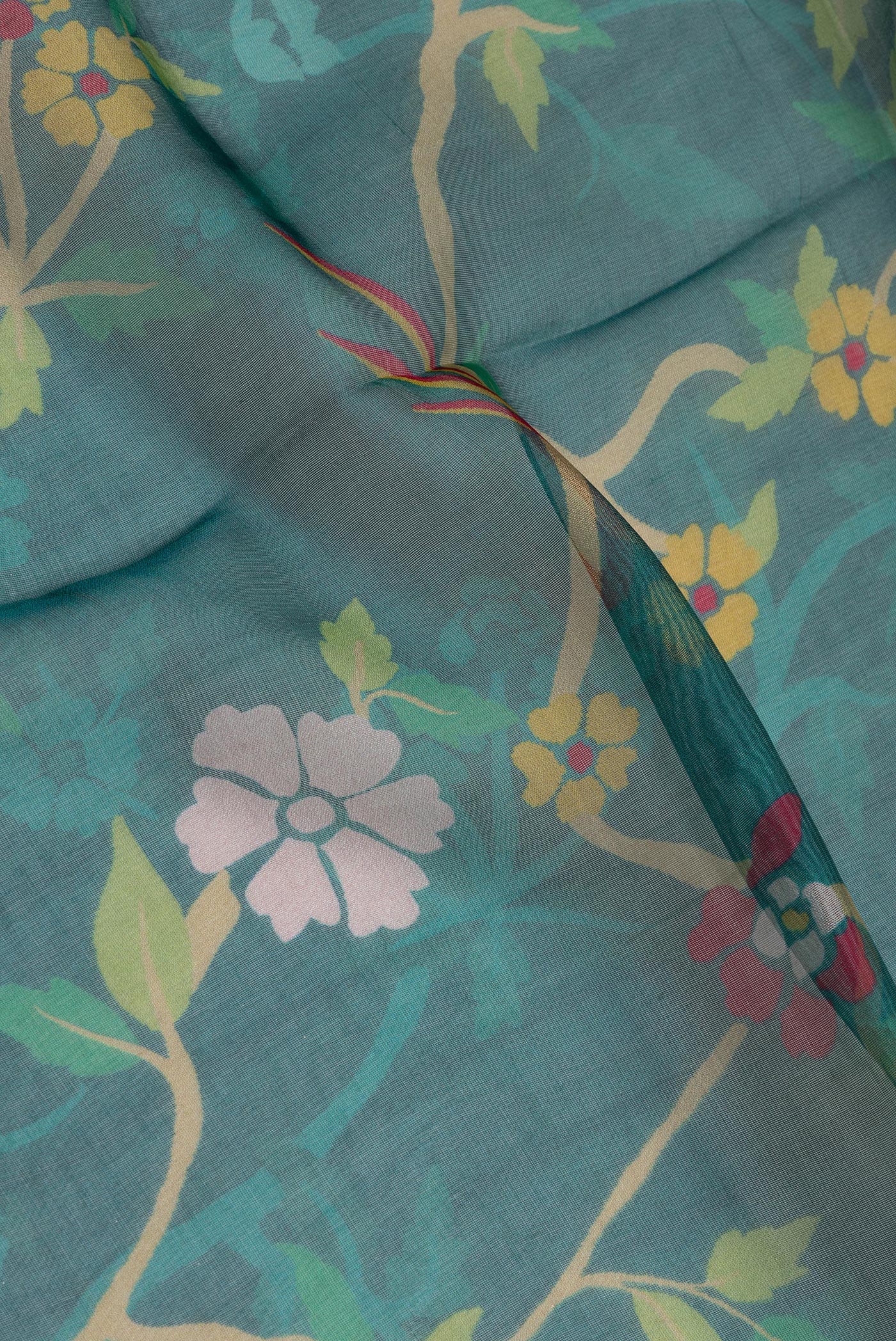 Close up of Peacock Blue Organza Silk Saree with Bird Print on the body and Zari Border.  displaying folds