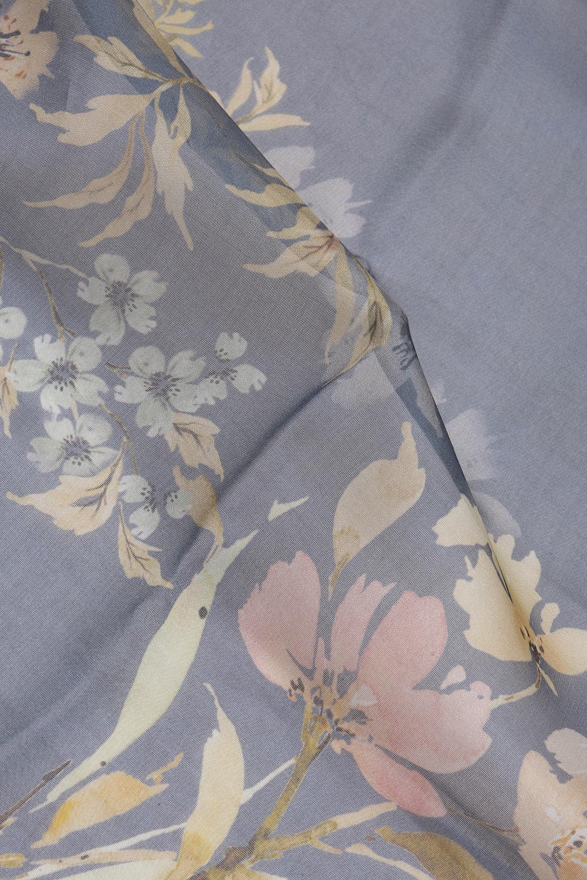 Close up of Blue Grey Organza Silk Saree with Floral Print on the body and Zari Border.  displaying folds