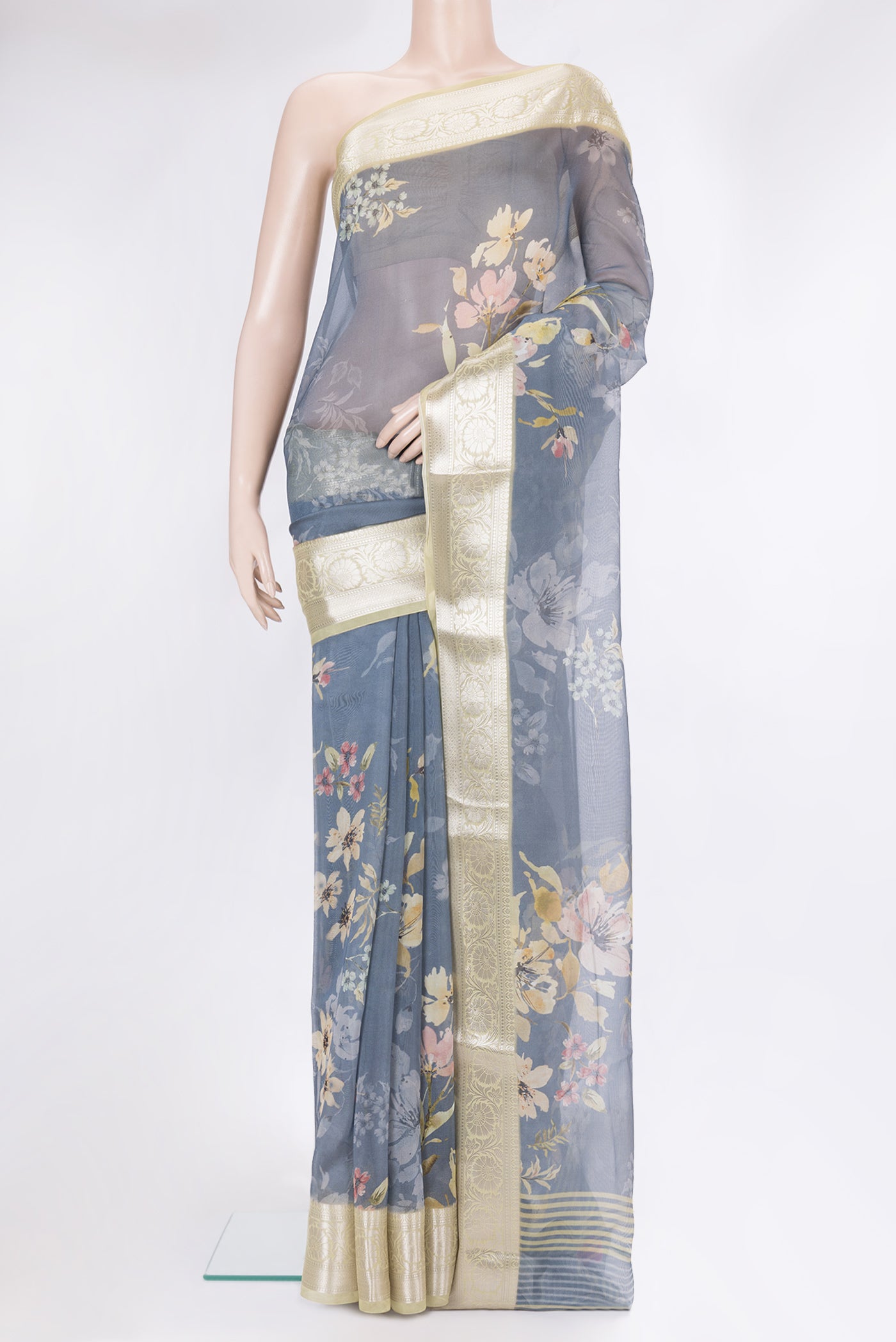 Blue Grey Organza Silk Saree with Floral Print on the body and Zari Border.  displayed on a mannequin