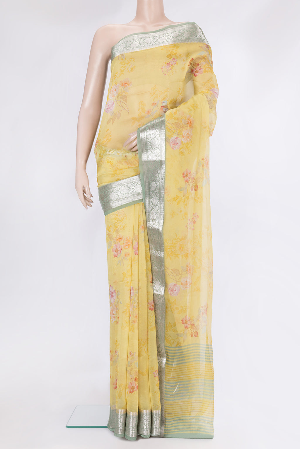 Yellow Organza Silk Saree with Floral Print on the body and Zari Border.  displayed on a mannequin