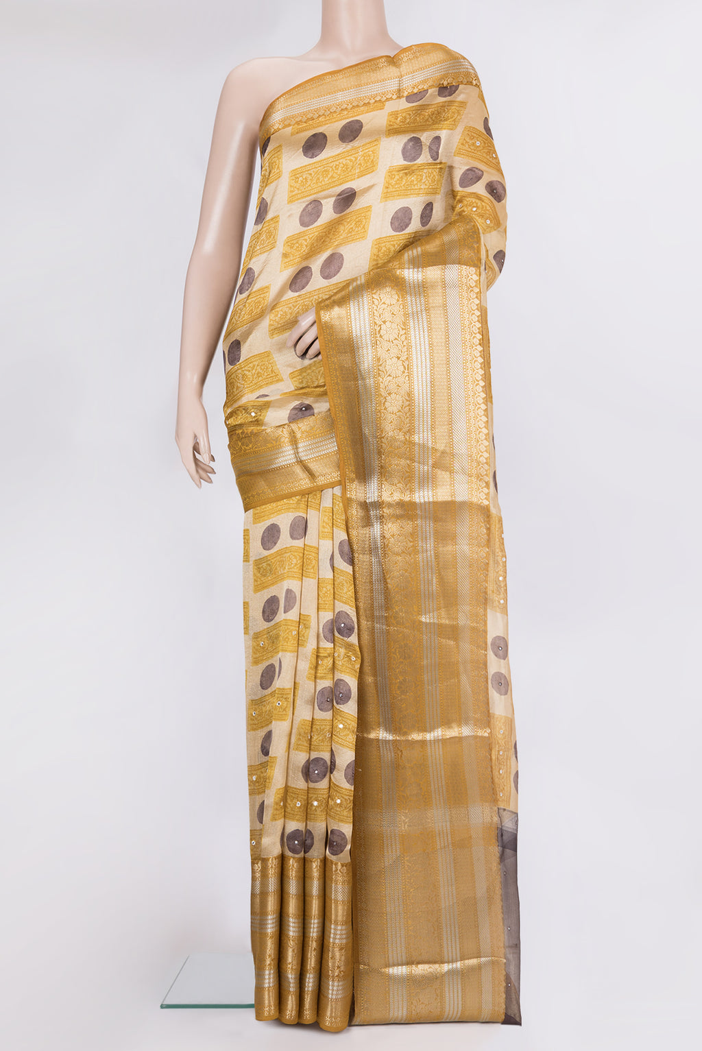 Beige Tussar Saree with Printed design on the body and Zari And Thread Border.  displayed on a mannequin