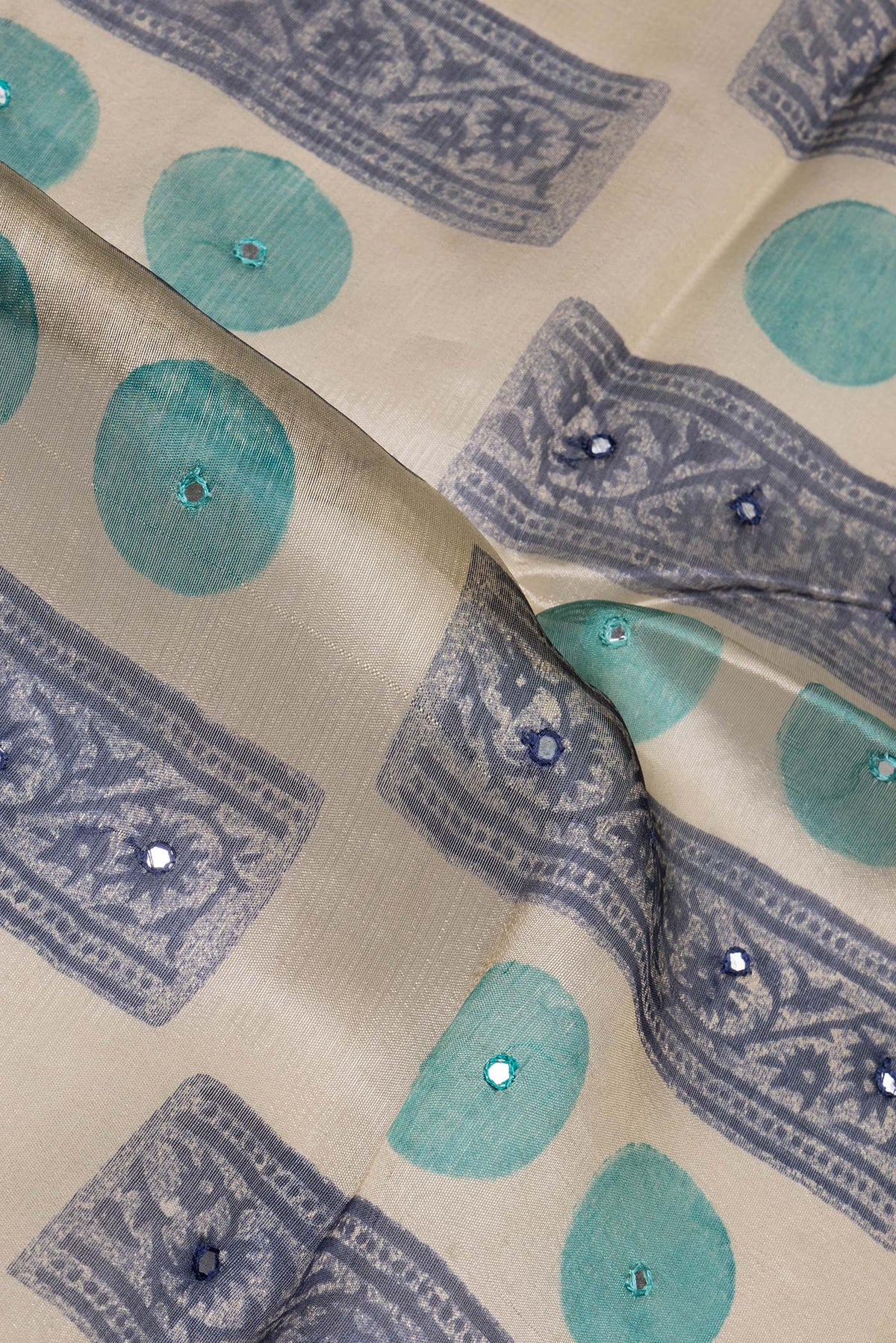 Close up of Beige Tussar Saree with Printed design on the body and Zari And Thread Border.  displaying folds