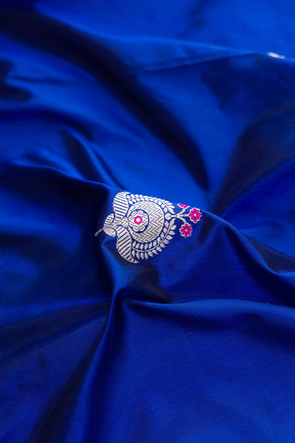 Close up of Royal Blue Dual Tone Banarasi Silk Saree with Zari And Thread Butta on the body and Fancy Border.  displaying folds