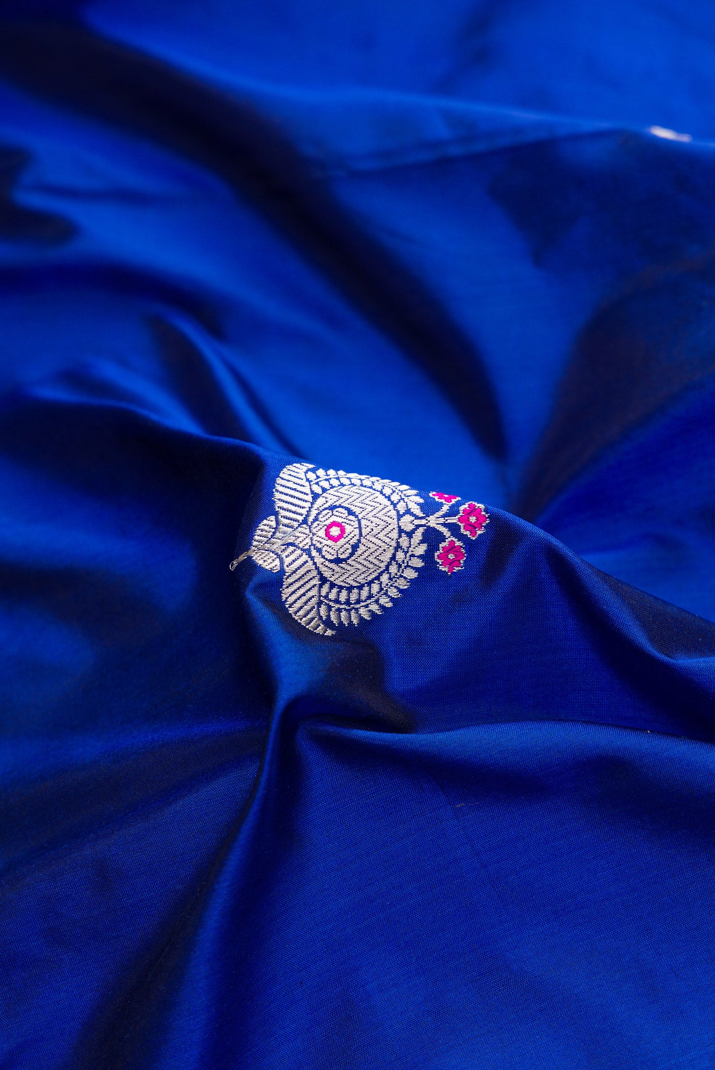 Close up of Royal Blue Dual Tone Banarasi Silk Saree with Zari And Thread Butta on the body and Fancy Border.  displaying folds