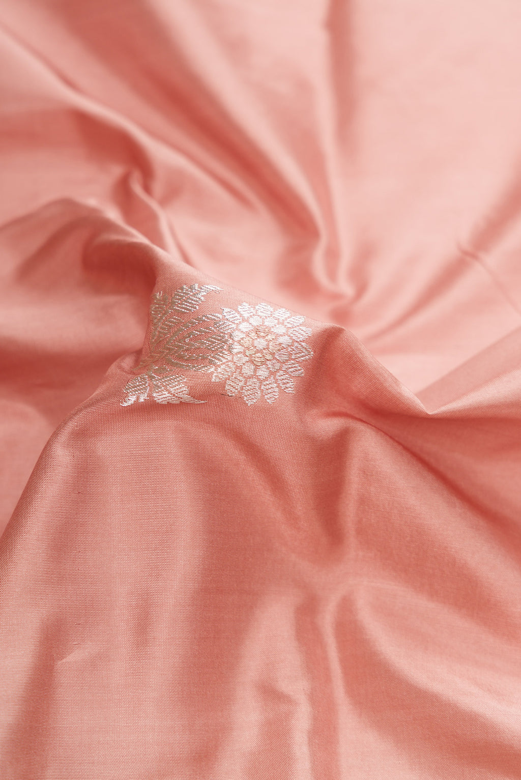Close up of Golden Peach Dual Tone Banarasi Silk Saree with Zari And Thread Butta on the body and Fancy Border.  displaying folds