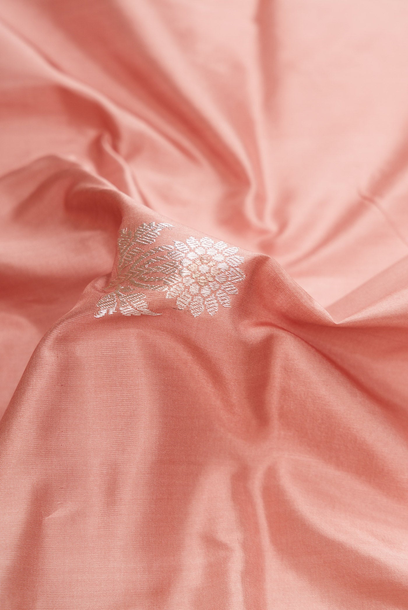 Close up of Golden Peach Dual Tone Banarasi Silk Saree with Zari And Thread Butta on the body and Fancy Border.  displaying folds