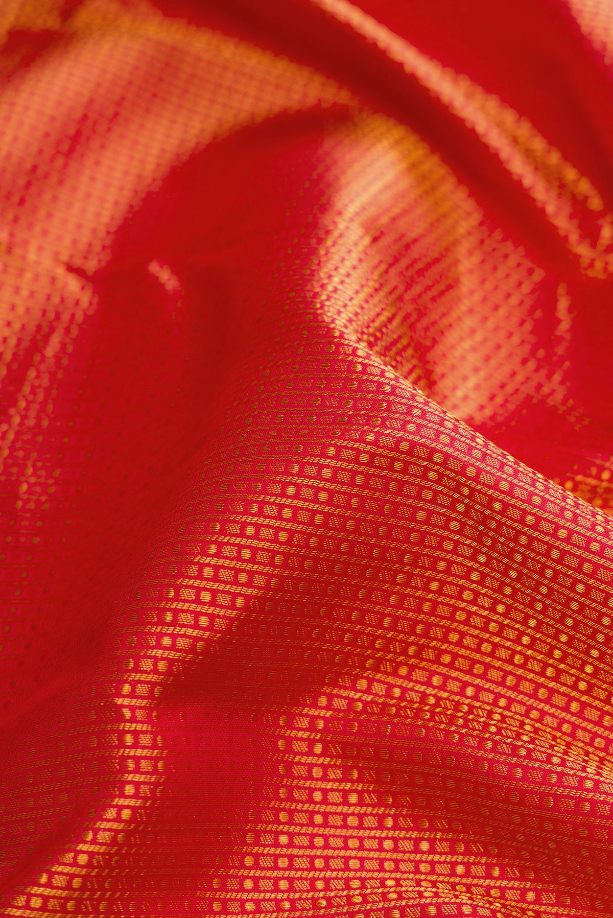 Close up of Red Kanjivaram Silk Saree with Zari Brocade on the body and Zari Border.  displaying folds