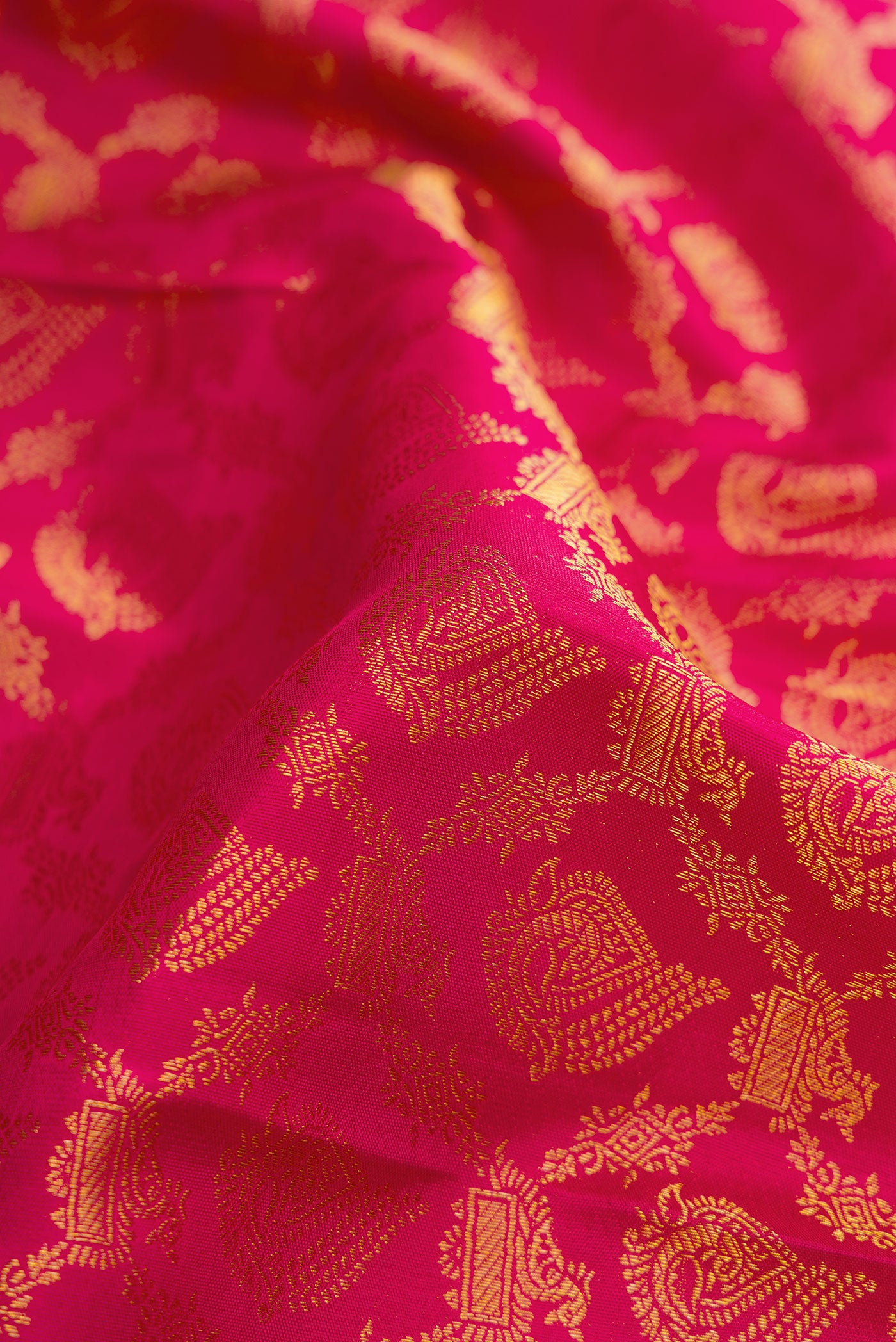 Close up of Dark Pink Kanjivaram Silk Saree with Zari Brocade on the body and Zari Border.  displaying folds